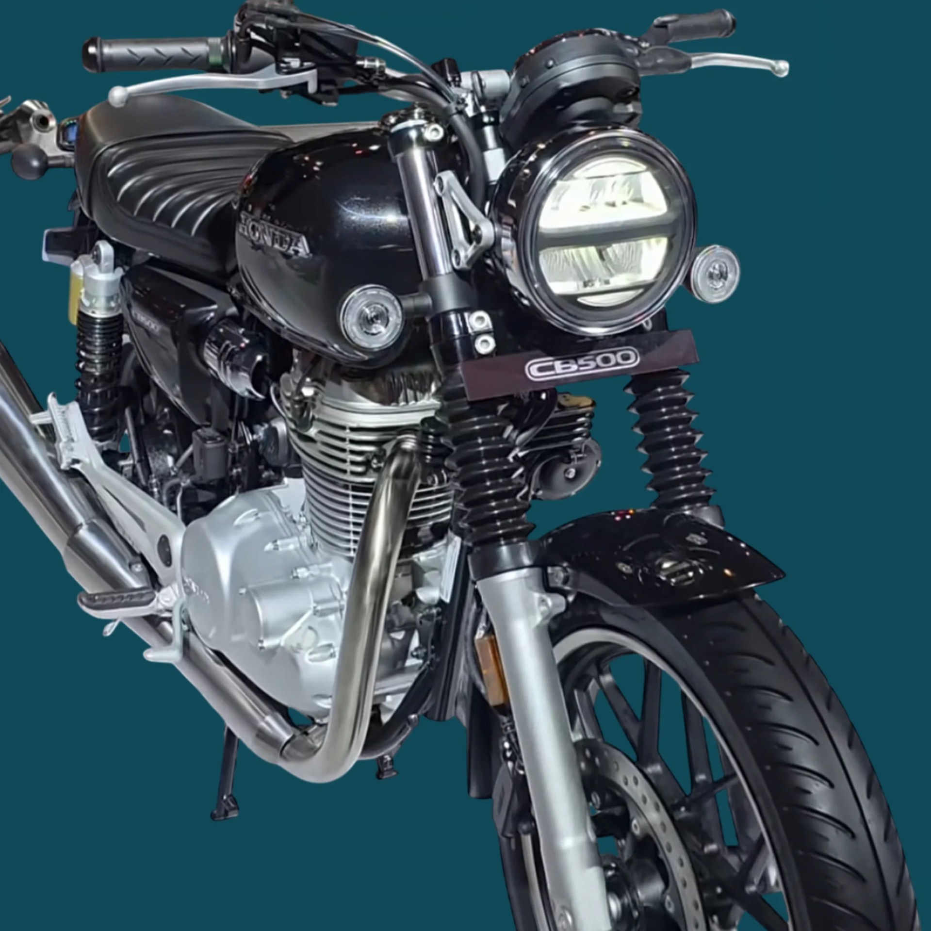 Black Honda CB500 motorcycle front with round LED headlight and silver engine components.