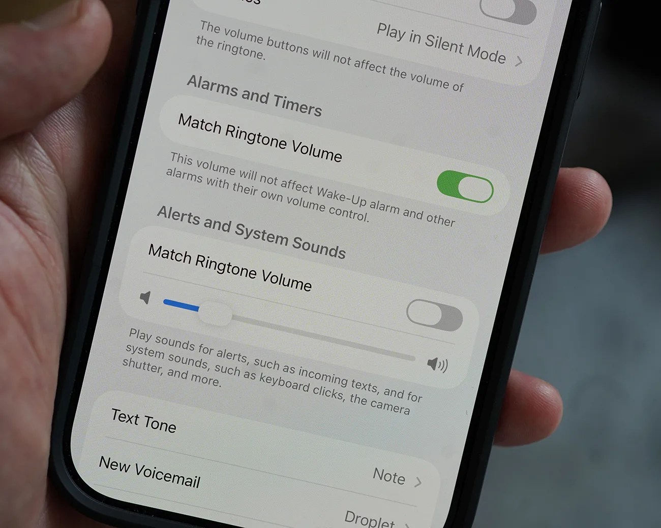 Close-up of a smartphone screen showing sound settings with "Match Ringtone Volume" toggled on for Alarms and Timers and off for Alerts and System Sounds.