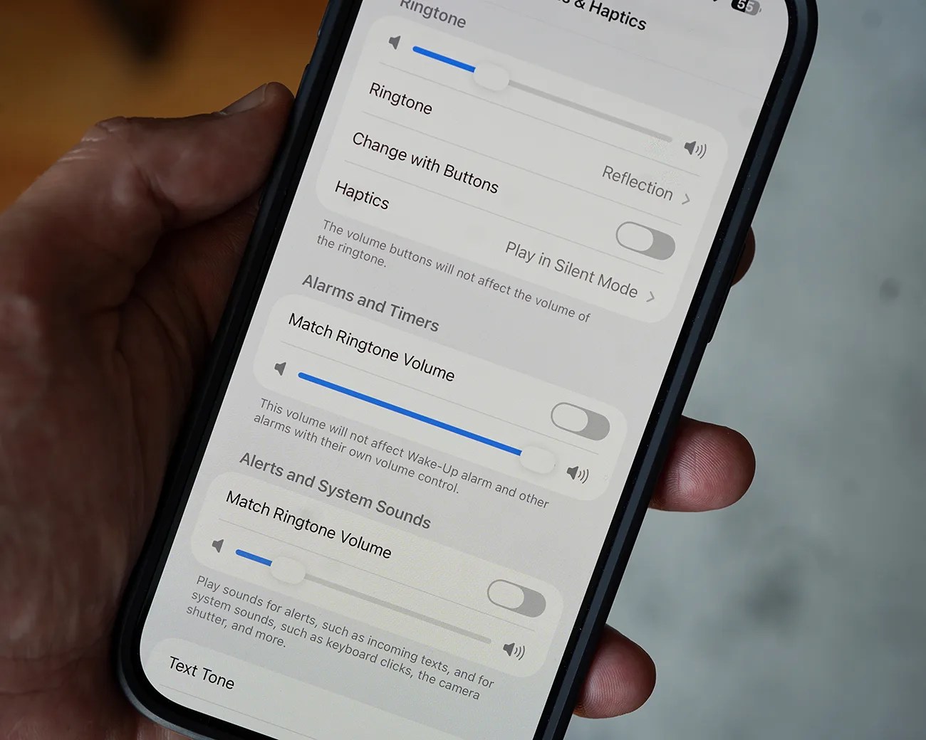 Smartphone screen showing sound settings with volume sliders and toggle switches for ringtone, alarms, and system sounds.