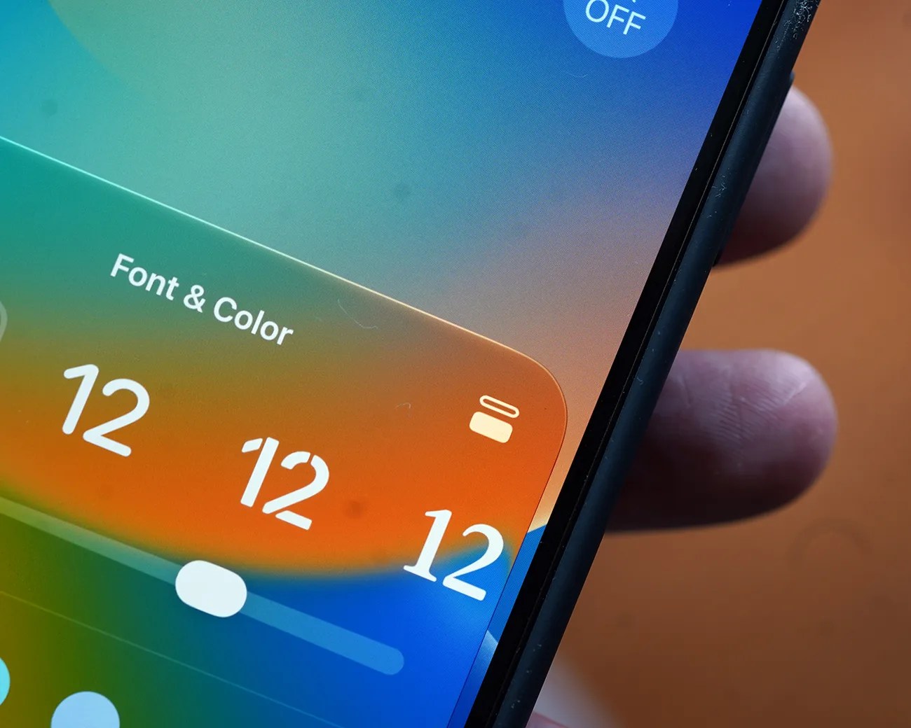Close-up of a smartphone screen showing a font and color size adjustment slider set to 12.