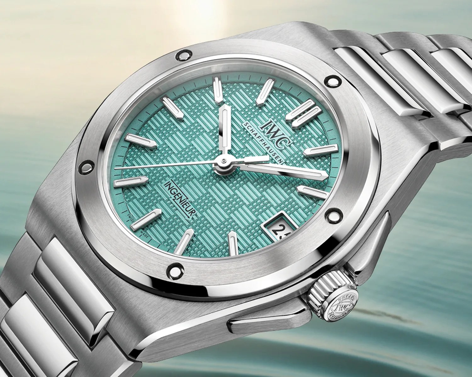 Silver stainless steel wristwatch with a textured turquoise dial, silver hour markers, and date display at 3 o'clock.