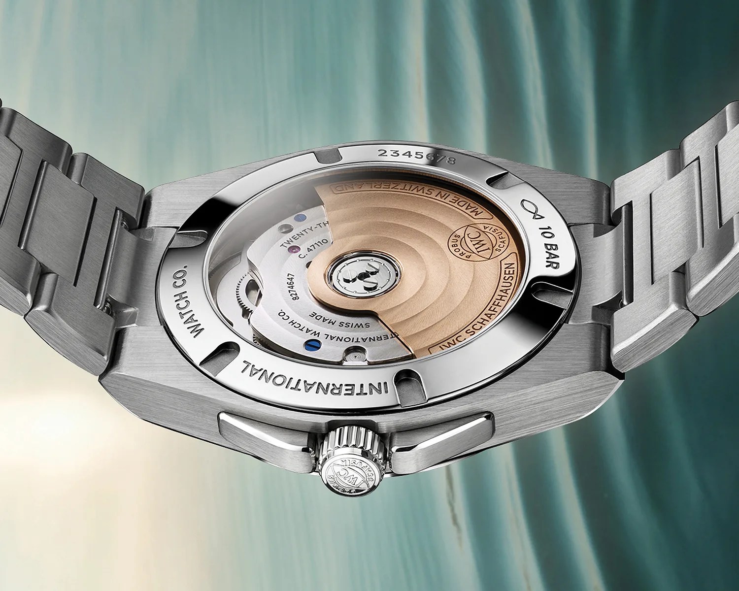 Stainless steel watch back showing automatic movement with gold rotor and engraved details.