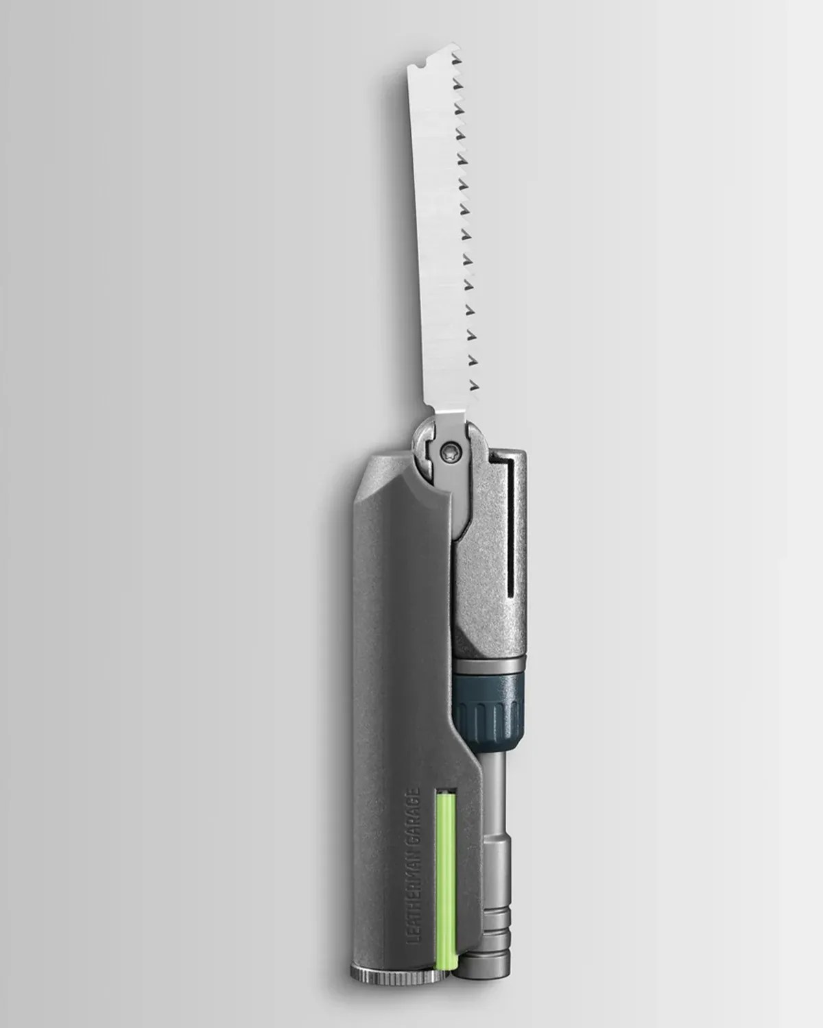 Compact gray multitool with a serrated saw blade extended and a green accent strip.