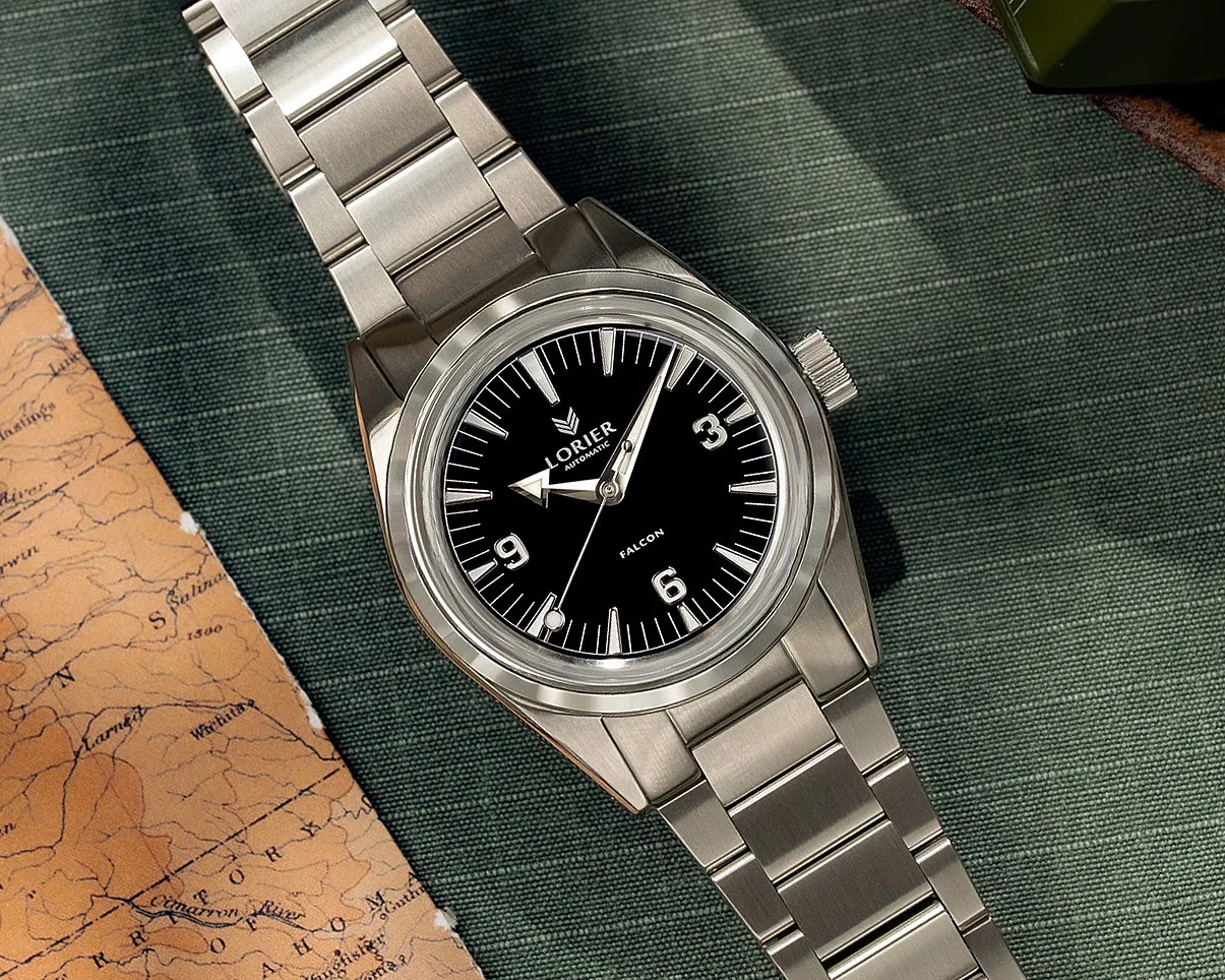Stainless steel Lorier Falcon automatic wristwatch with black dial and silver bracelet on green fabric.