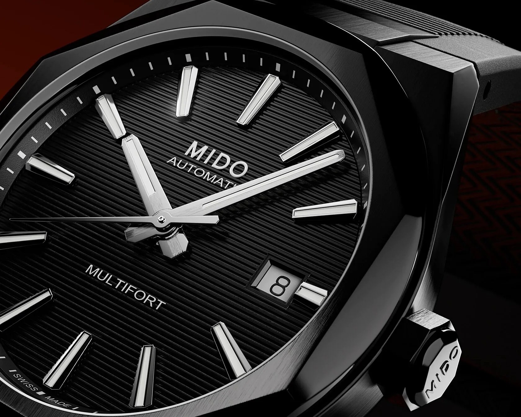 Close-up of a black Mido Multifort automatic watch face with silver hour markers and date window showing the 8th.