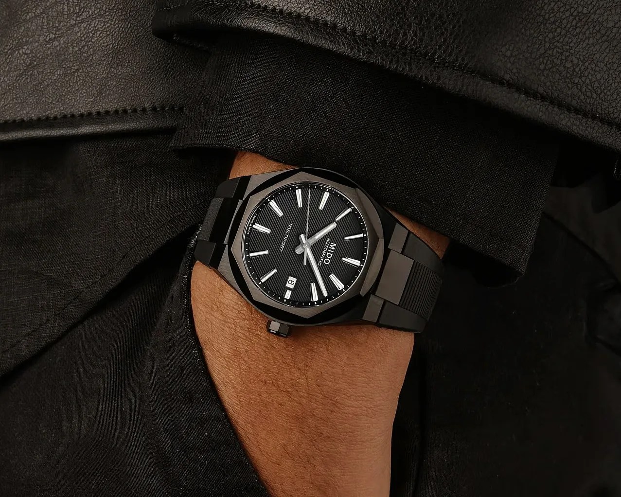 Black Mido Multifort automatic wristwatch with a textured dial and date window worn on a wrist.