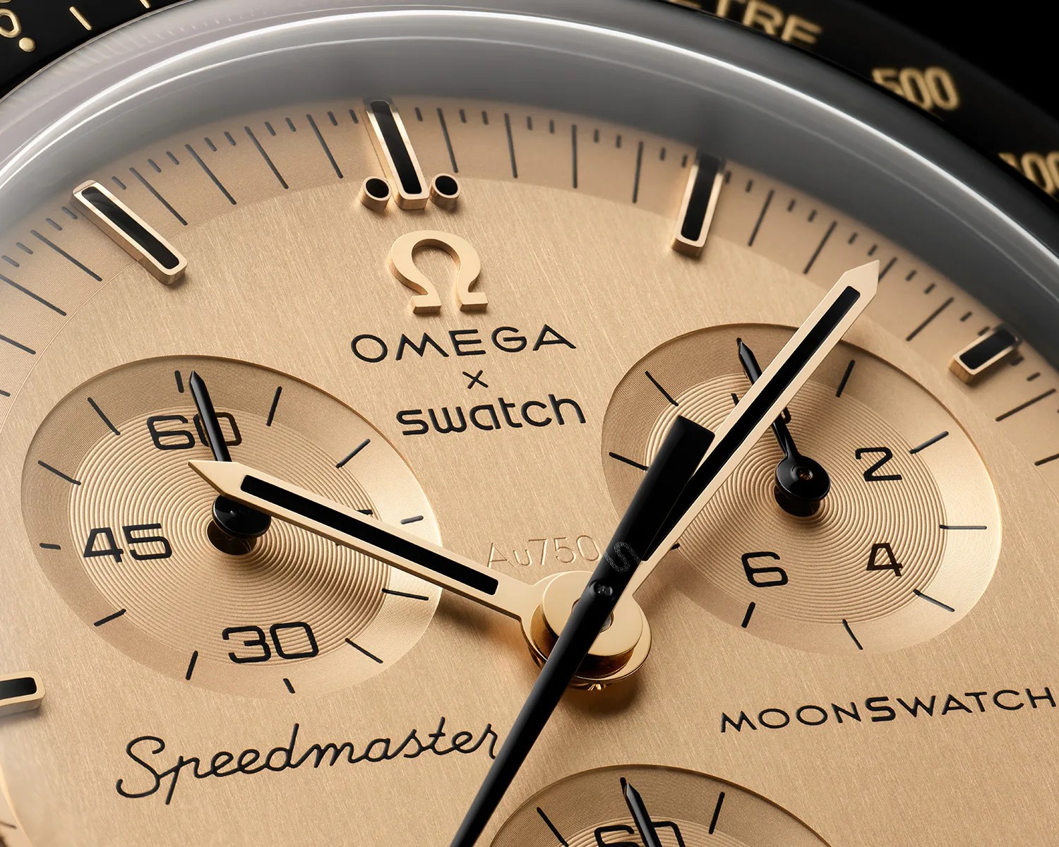 Close-up of a gold-toned Omega x Swatch Speedmaster MoonSwatch watch face with black and gold hands.