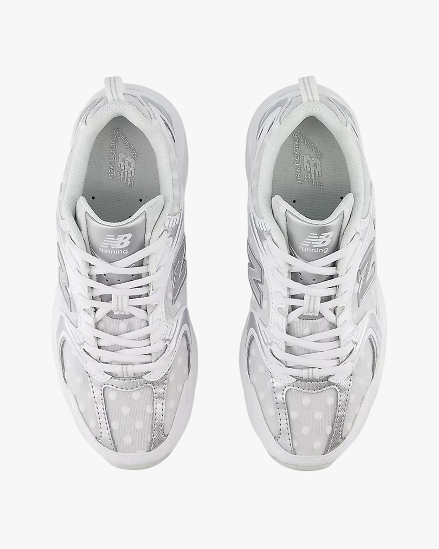 Pair of white New Balance running shoes with gray accents and polka dot mesh panels viewed from above.