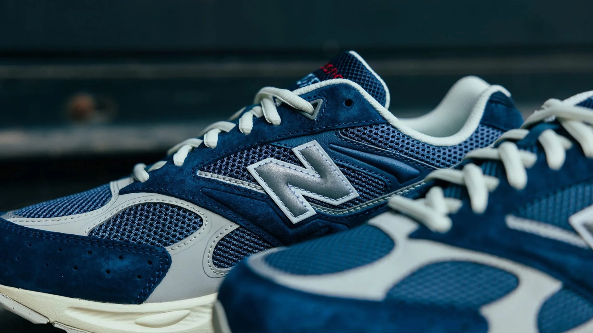 Pair of blue and white New Balance sneakers with mesh and suede panels and white laces.