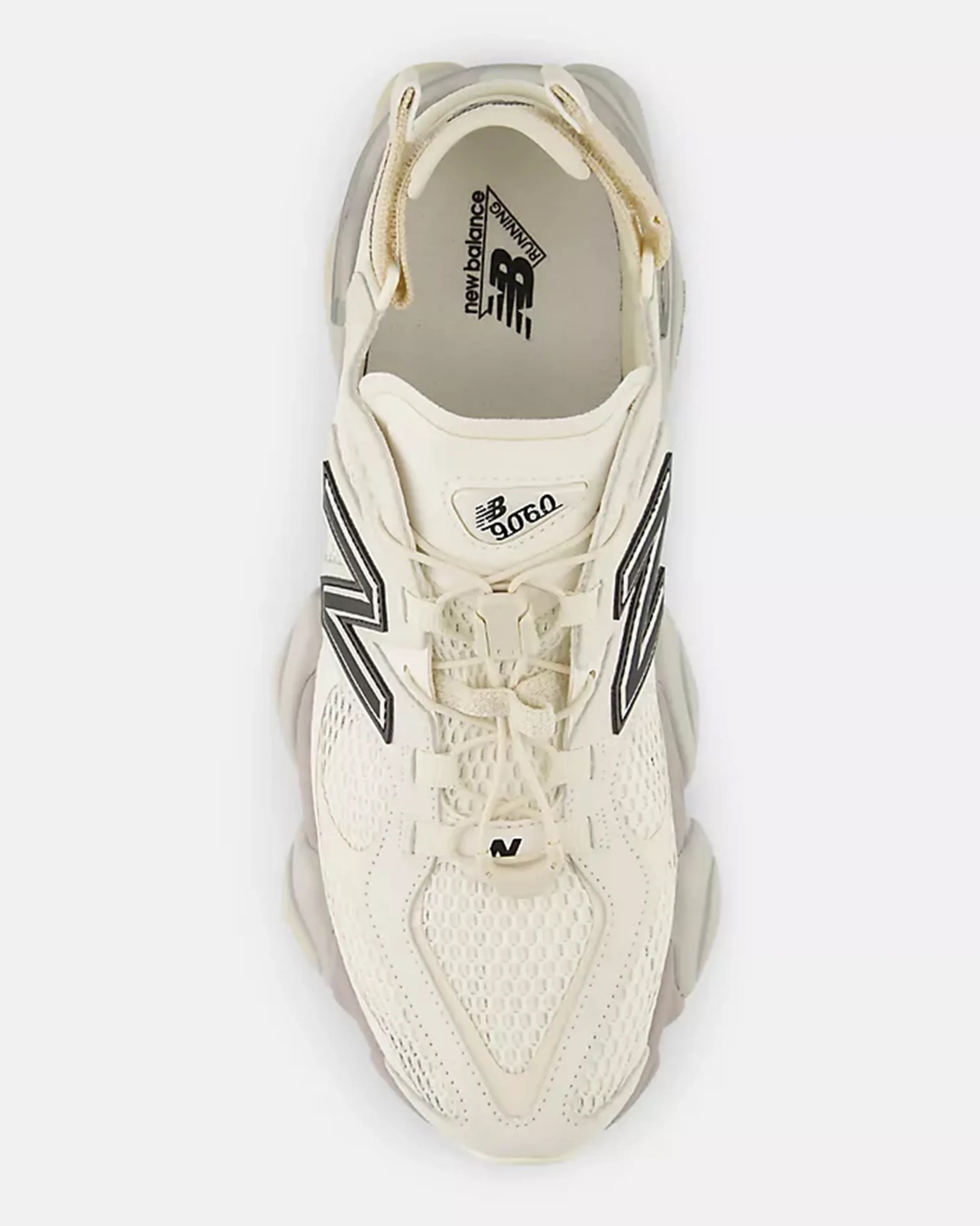 Cream-colored New Balance 9060 running shoe with black logo and mesh upper, viewed from above.