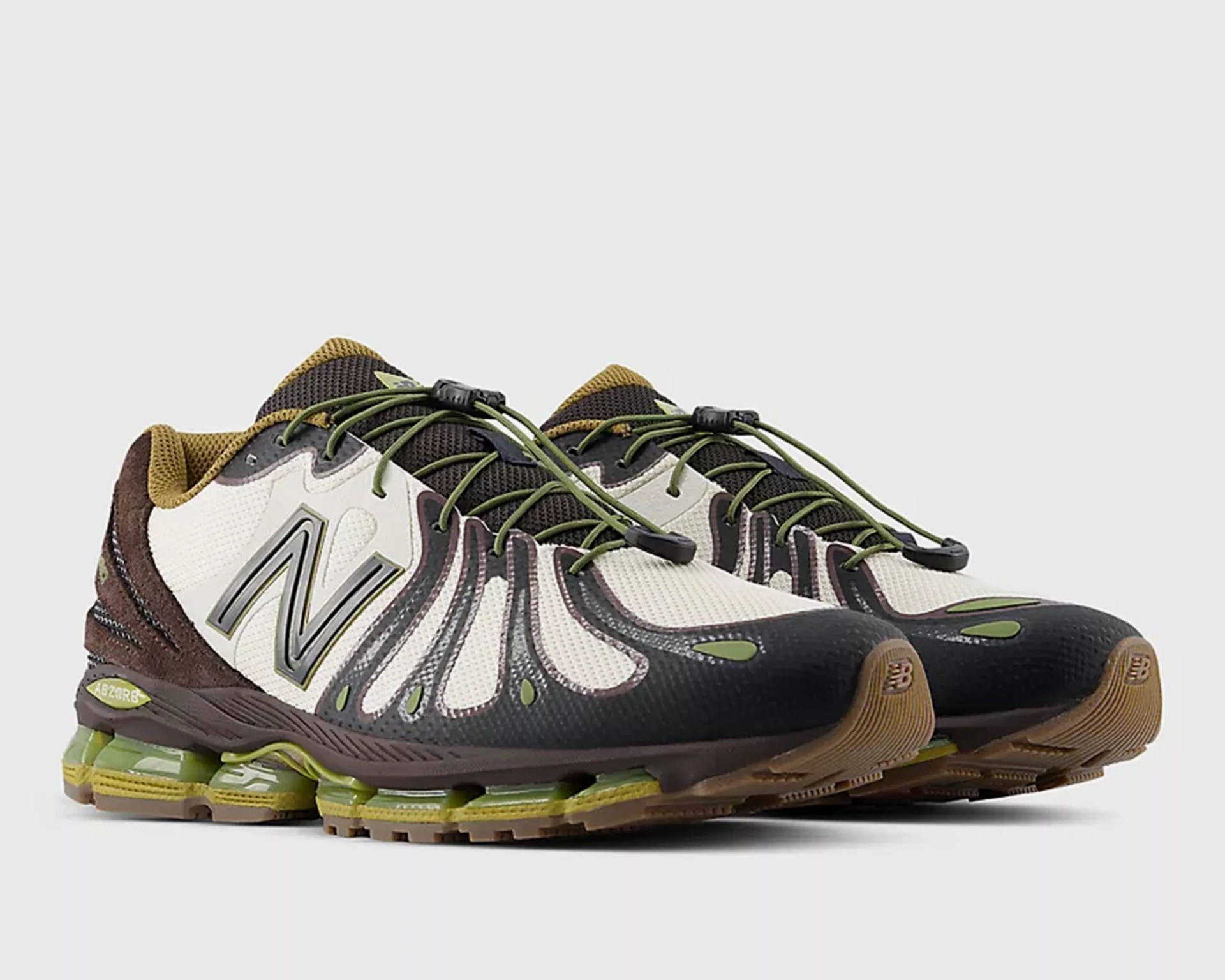 Pair of New Balance running shoes in white, black, brown, and green with mesh upper and cushioned sole.