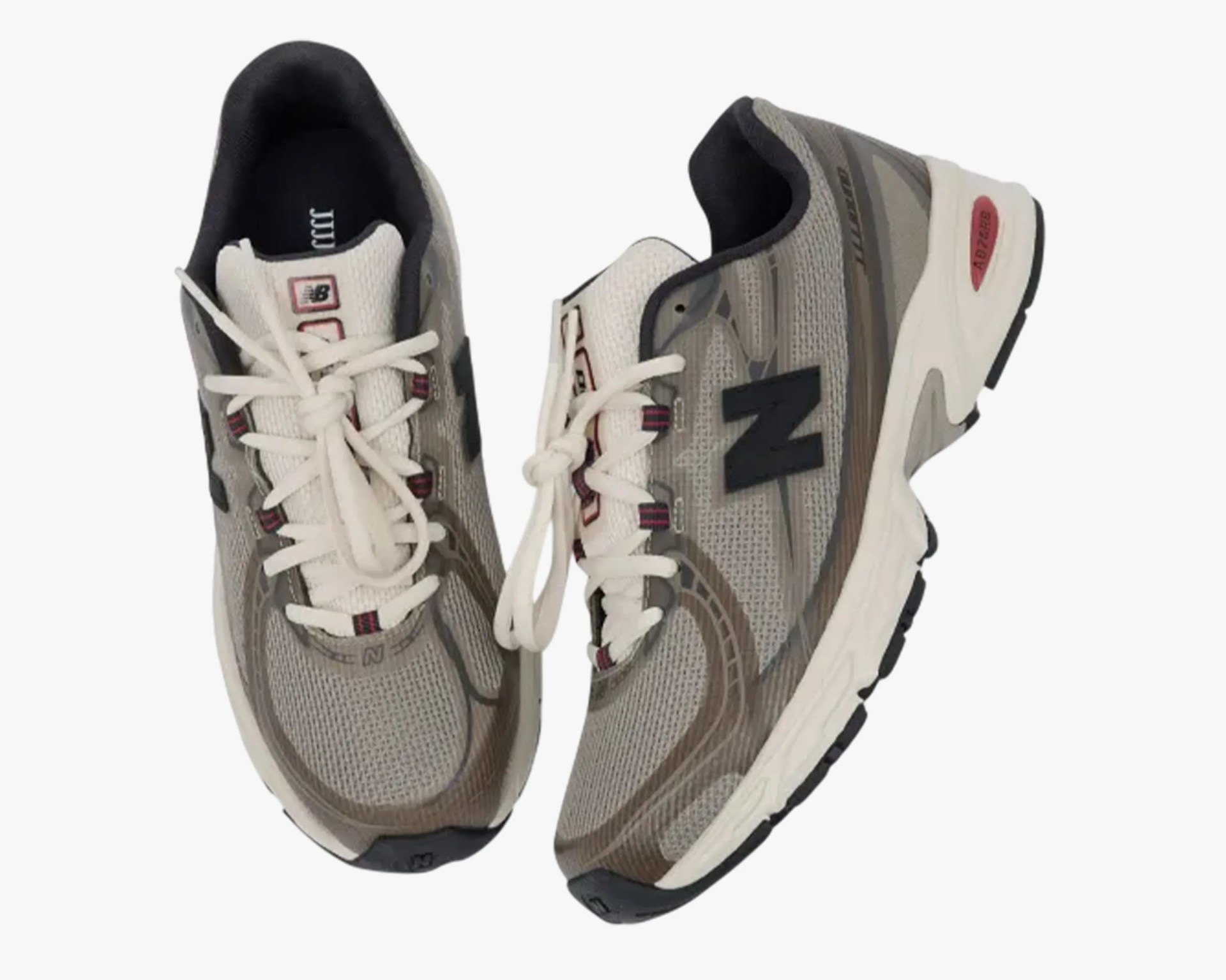 Pair of gray and beige New Balance running shoes with white laces and black soles.
