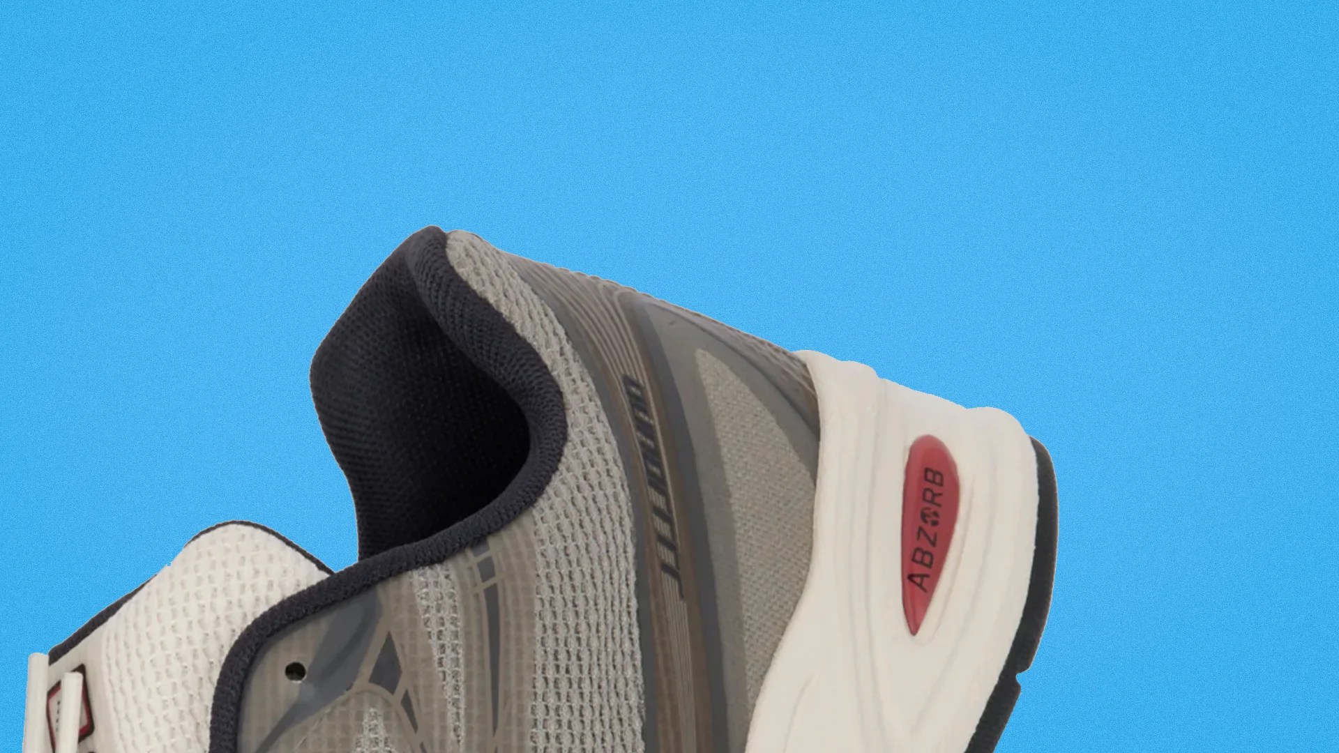 Gray and white running shoe with black inner lining and red ABZORB cushioning on a blue background.