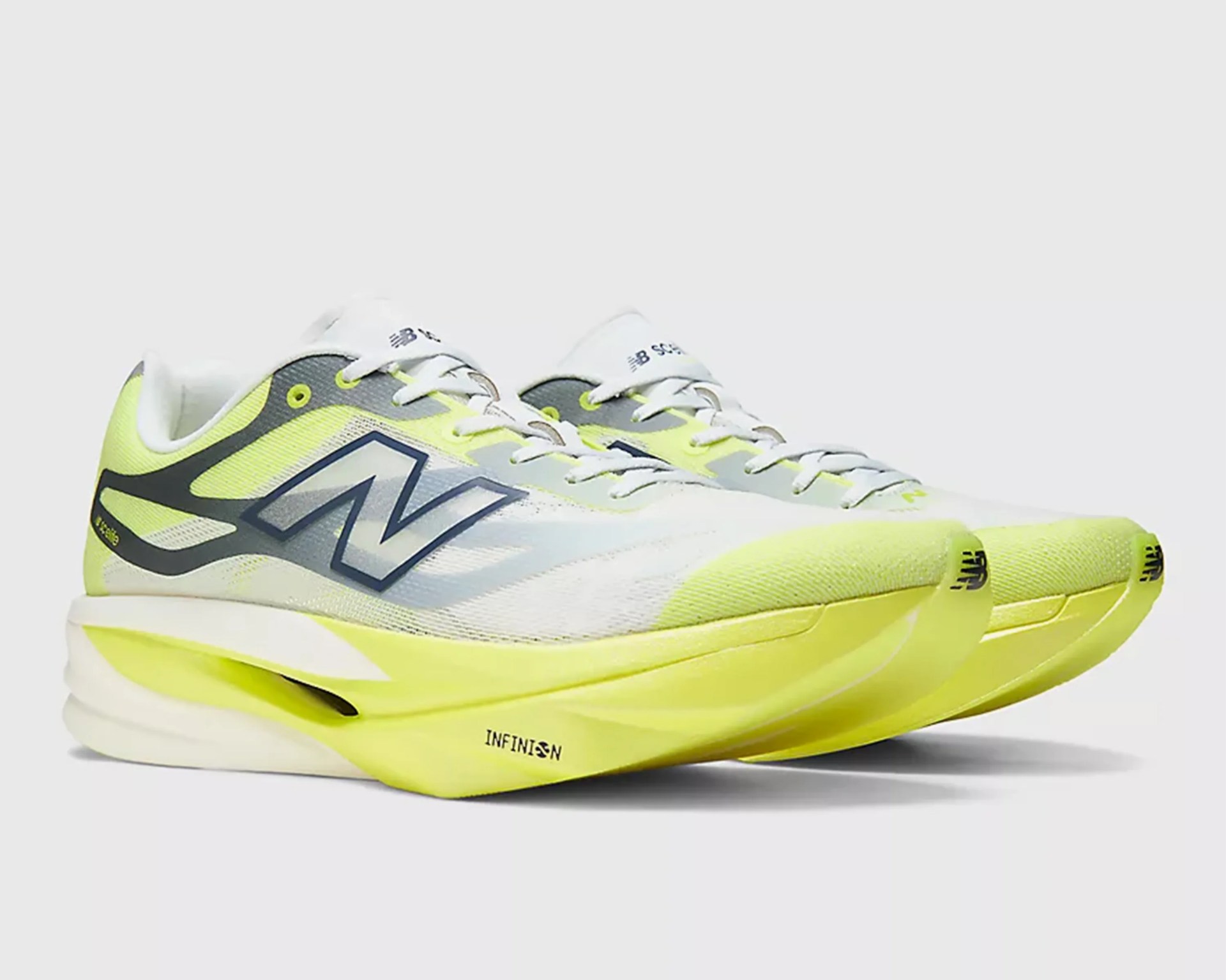 Pair of white and neon yellow New Balance running shoes with mesh upper and thick cushioned sole.