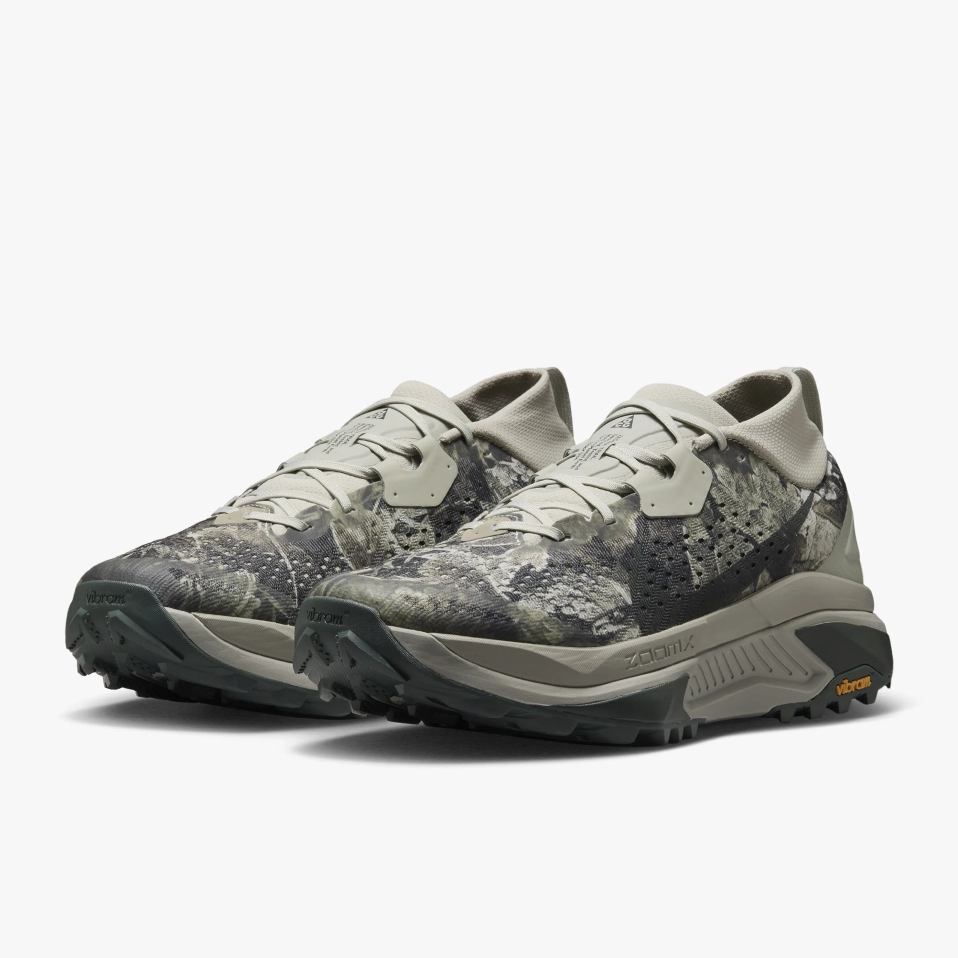 Pair of gray and beige camo-patterned athletic shoes with Vibram soles and ZoomX midsoles.