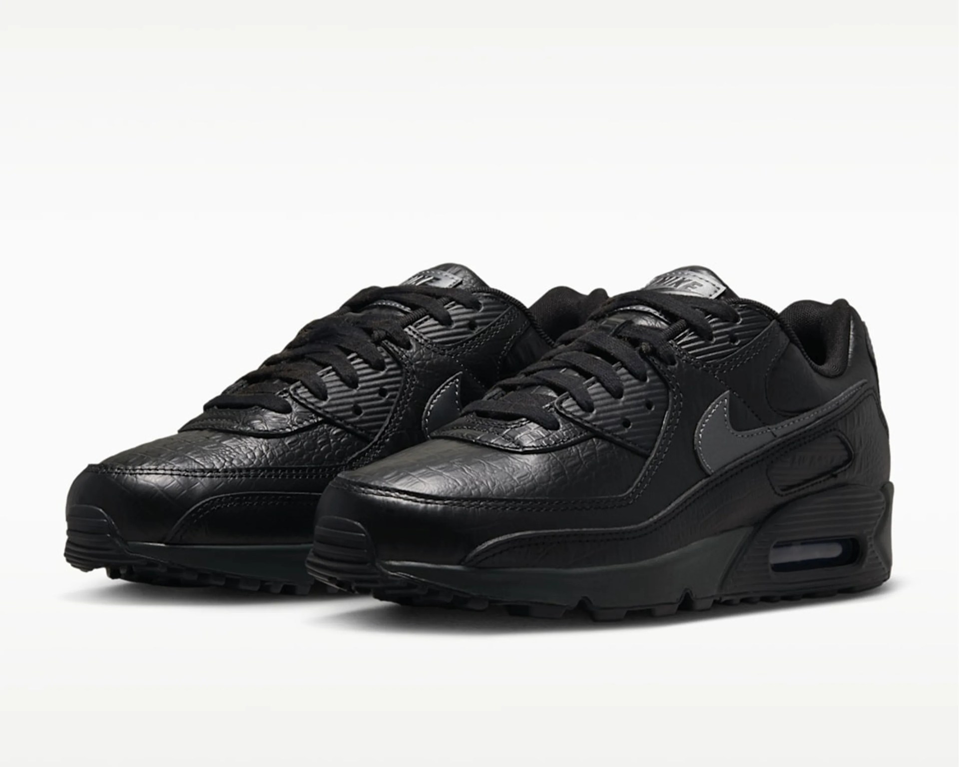 Pair of black Nike Air Max sneakers with textured leather and visible air cushion soles.