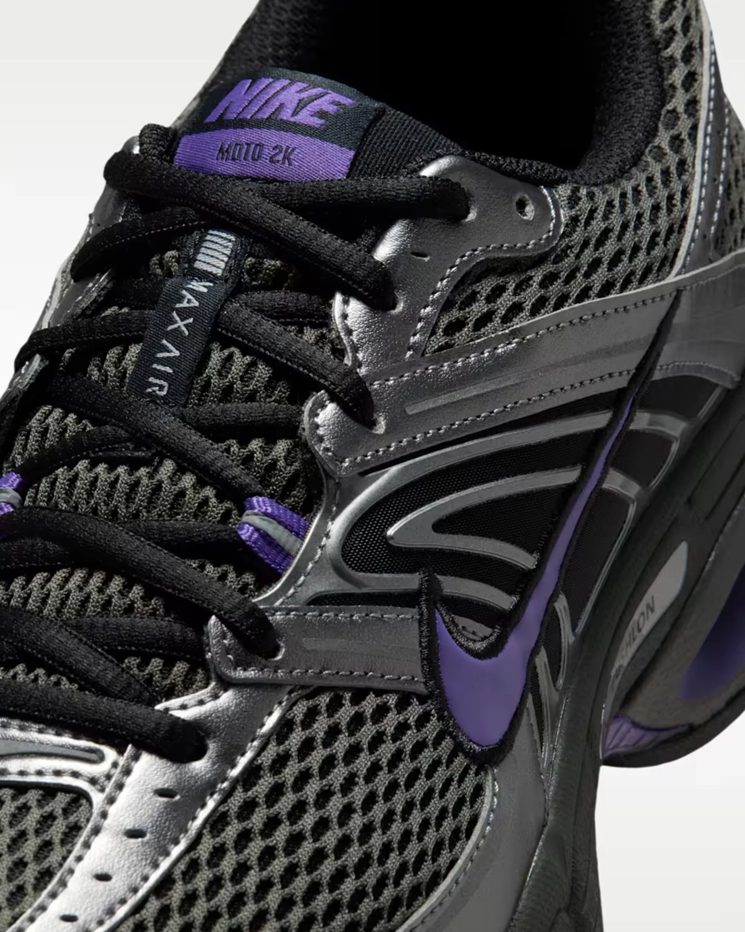 Close-up of black and purple Nike MOTO 2K sneaker with mesh upper and black laces.