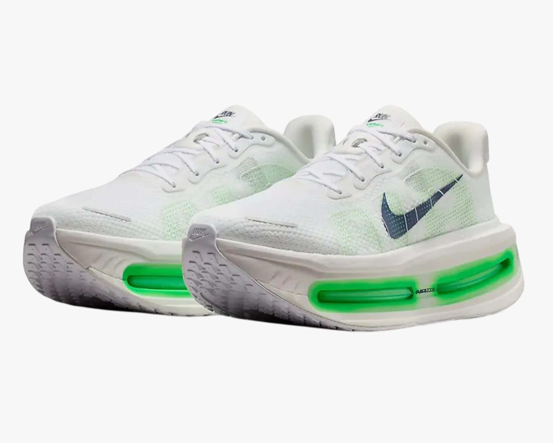 Pair of white Nike running shoes with black swoosh logo and green air cushion soles.