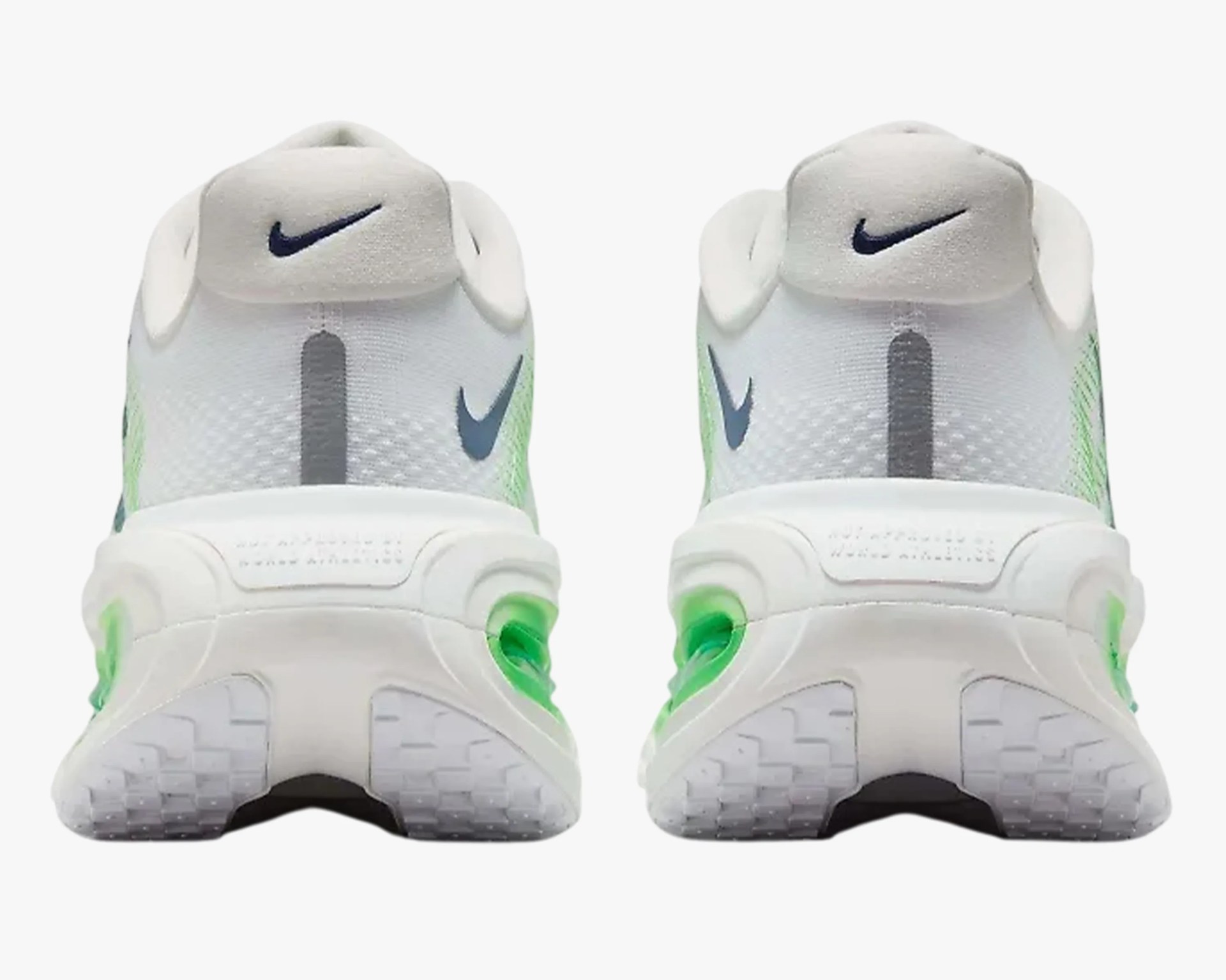 Pair of white Nike sneakers with green accents and black swoosh logos on the heel tab and sides.
