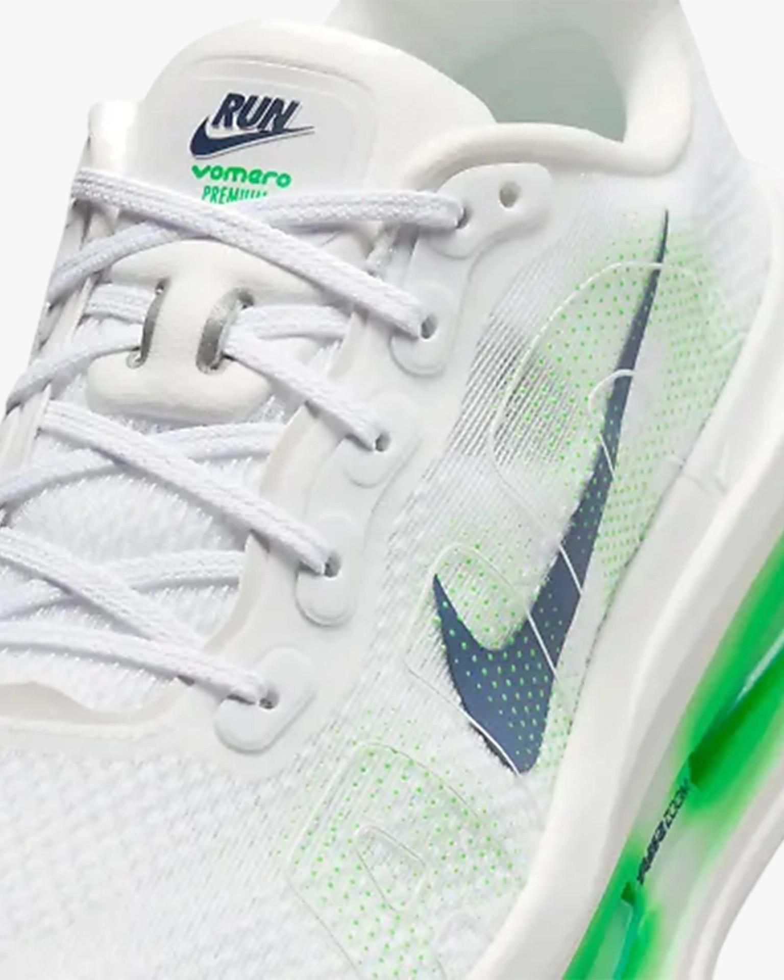 White Nike running shoe with green accents, navy swoosh logo, and white laces.