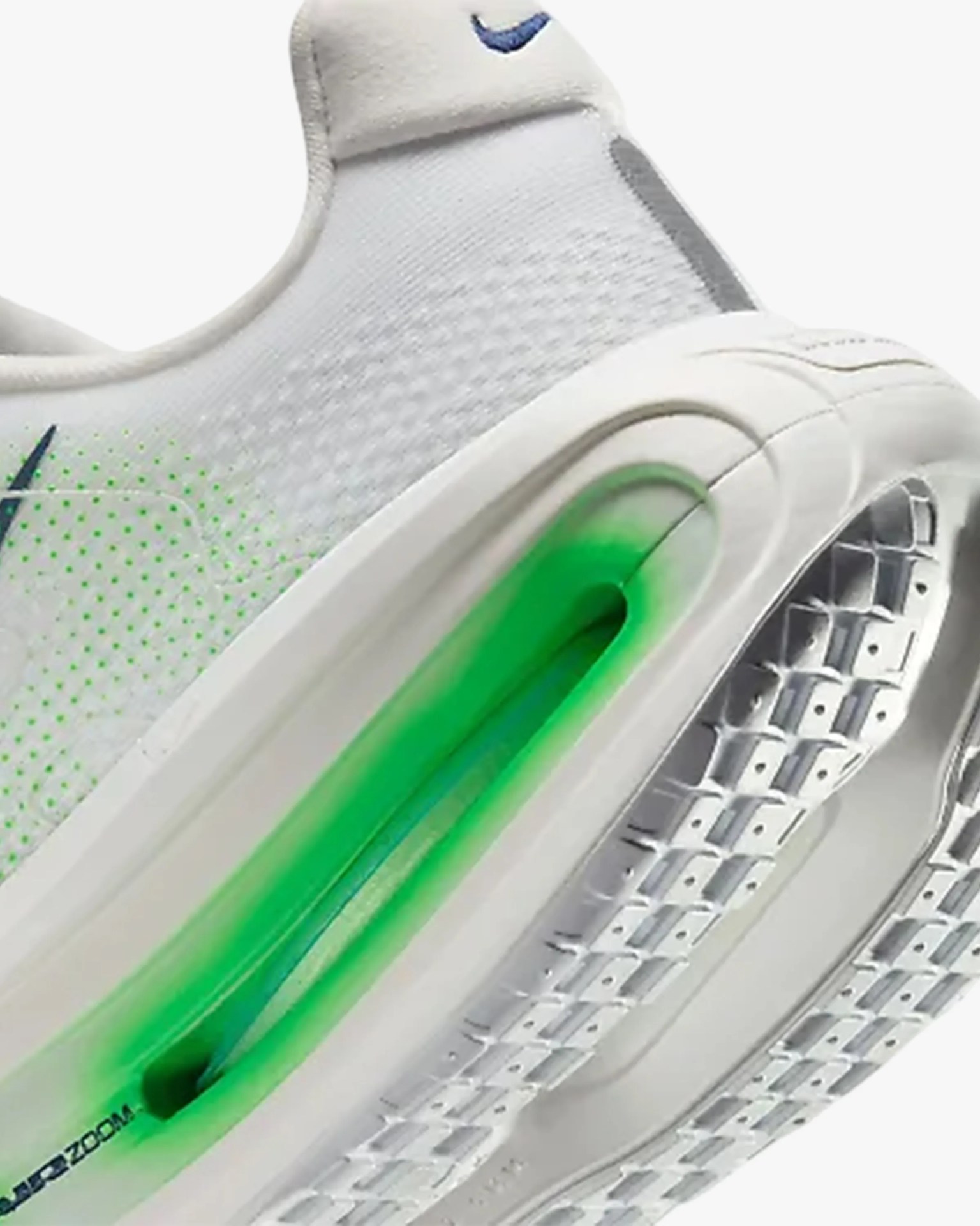 White Nike Air Zoom sneaker with green air cushion sole and blue swoosh logo.