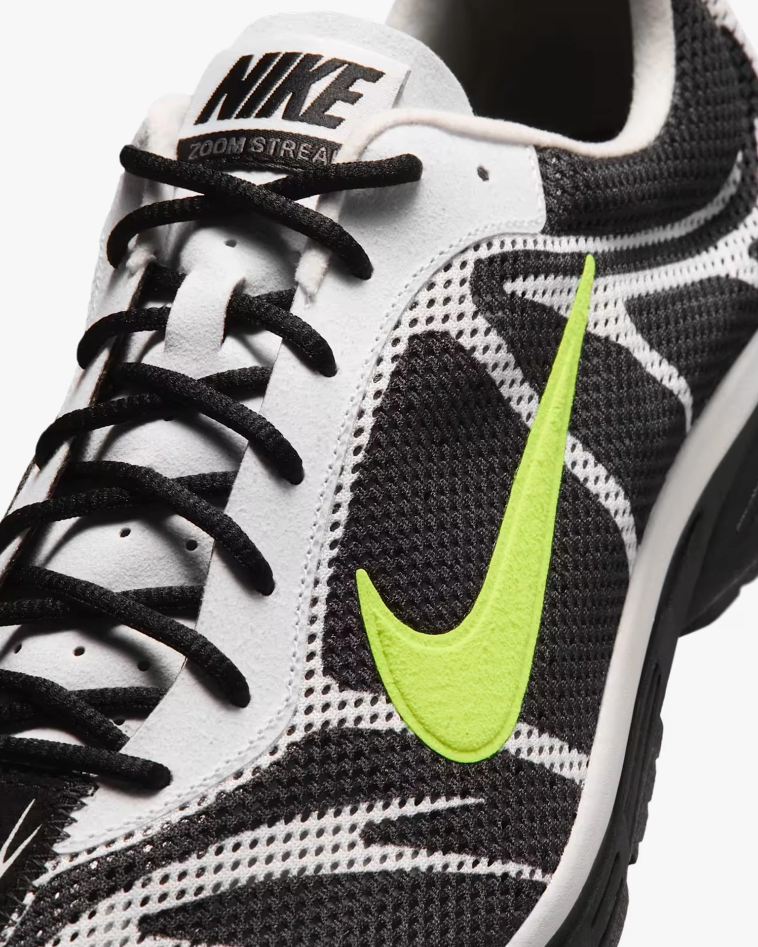 Close-up of a black and white Nike Zoom Streak sneaker with black laces and a bright yellow-green Nike swoosh.