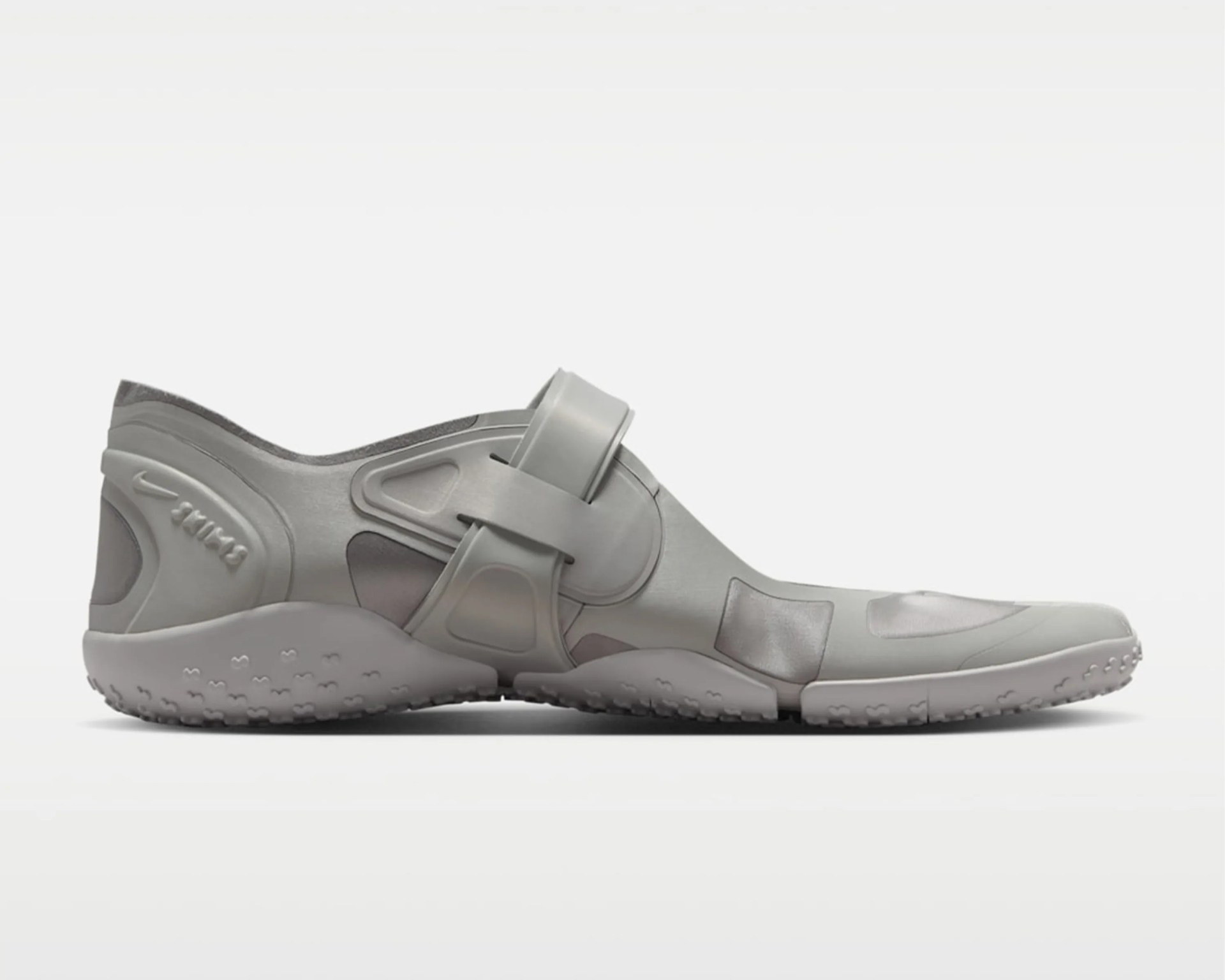 Light gray Nike water shoe with adjustable strap and textured sole.