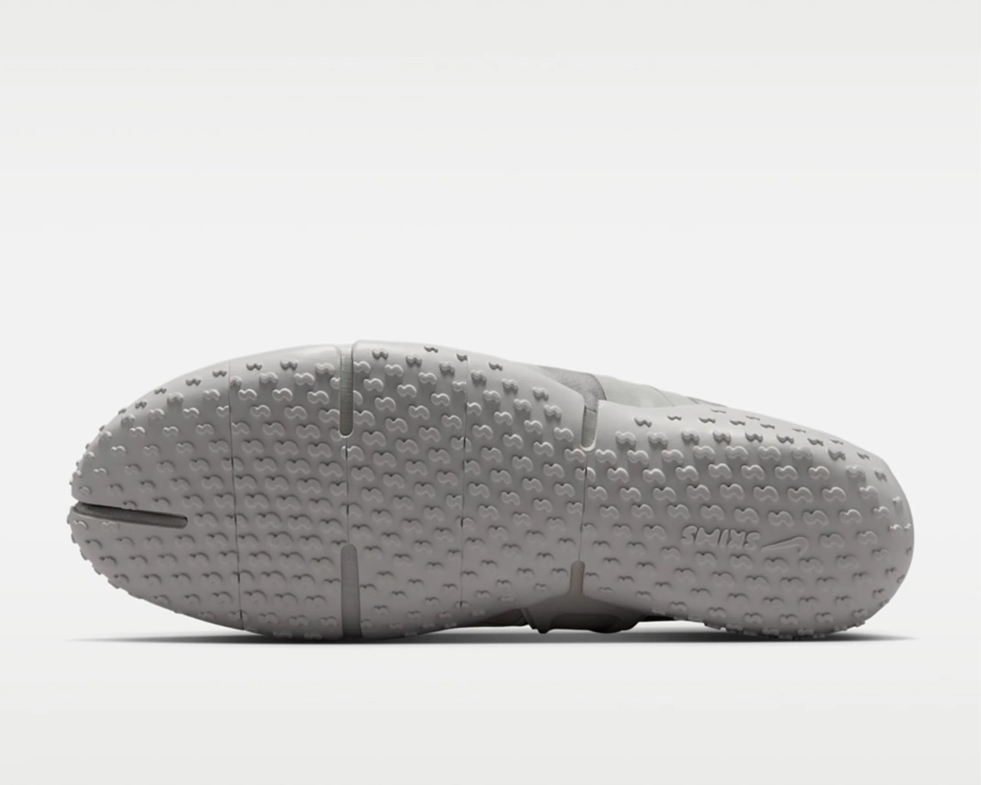 White rubber shoe sole with small textured patterns and "SWIMS" branding near the toe area.