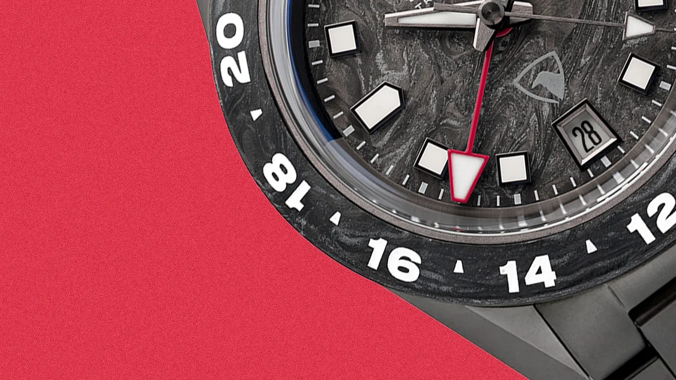 Close-up of a black watch face with white hour markers, a red-tipped second hand, and a date window showing "28" on a red background.