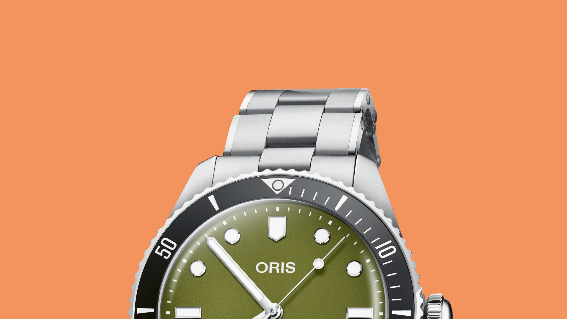 Close-up of a stainless steel Oris watch with an olive green dial and black bezel on an orange background.