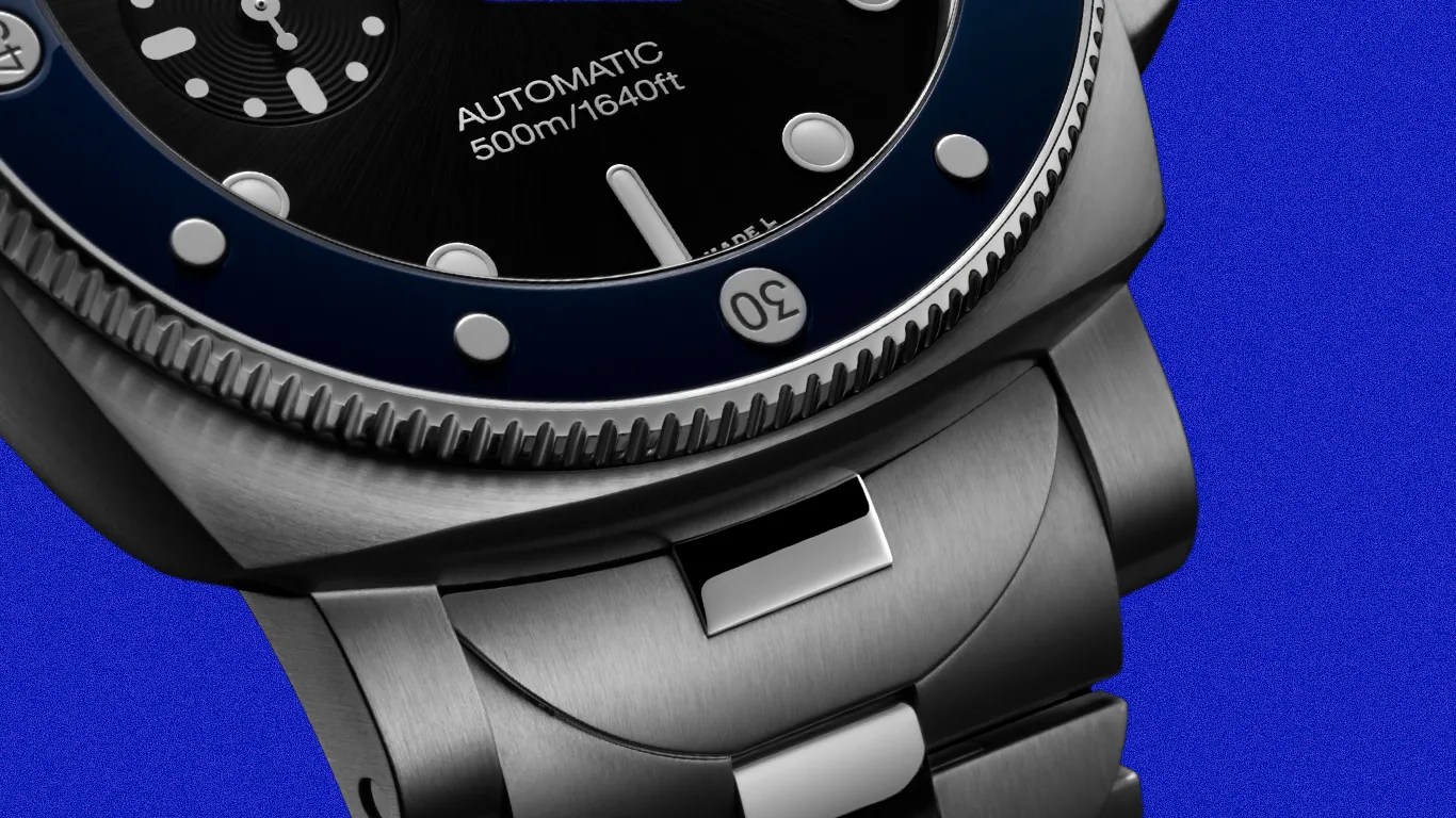 Close-up of a stainless steel automatic dive watch with a black dial and blue bezel, water-resistant to 500m/1640ft.