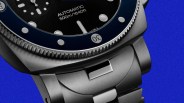 Close-up of a stainless steel automatic dive watch with a black dial and blue bezel, water-resistant to 500m/1640ft.