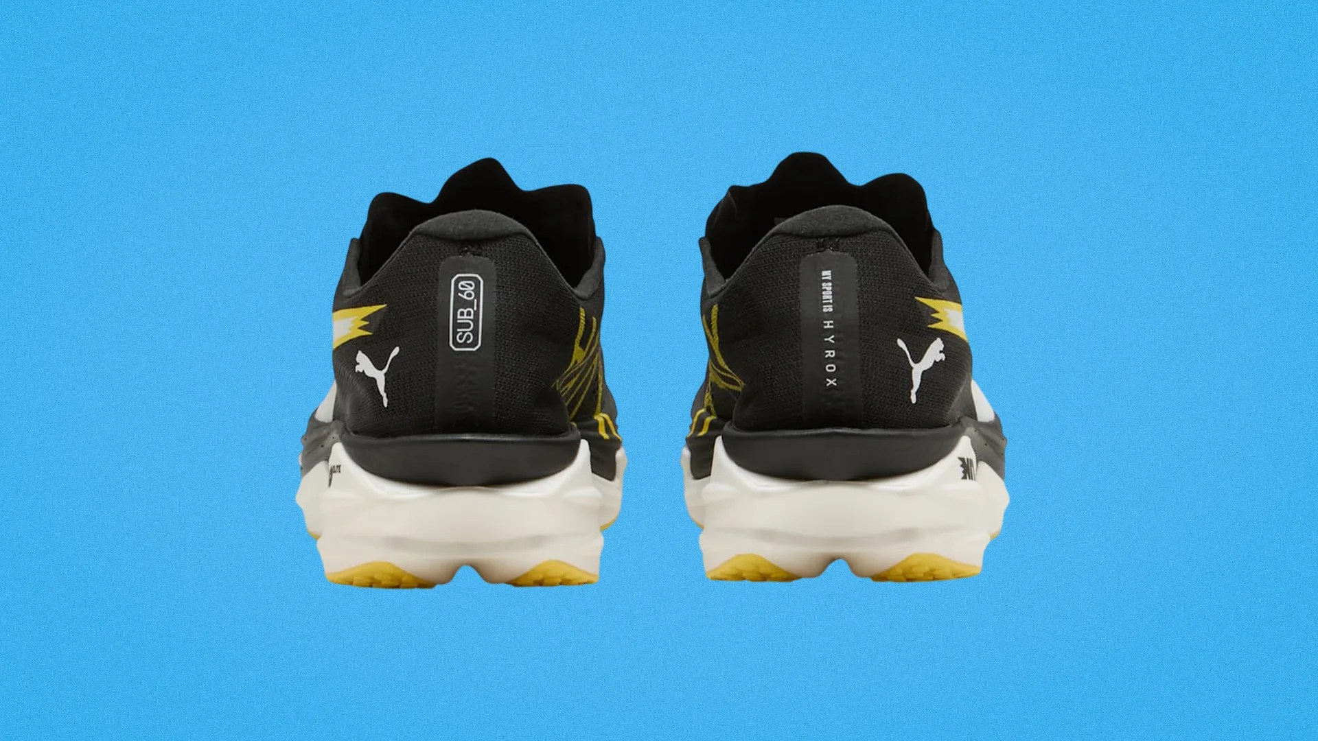 Pair of black Puma running shoes with white soles and yellow accents, viewed from the back.