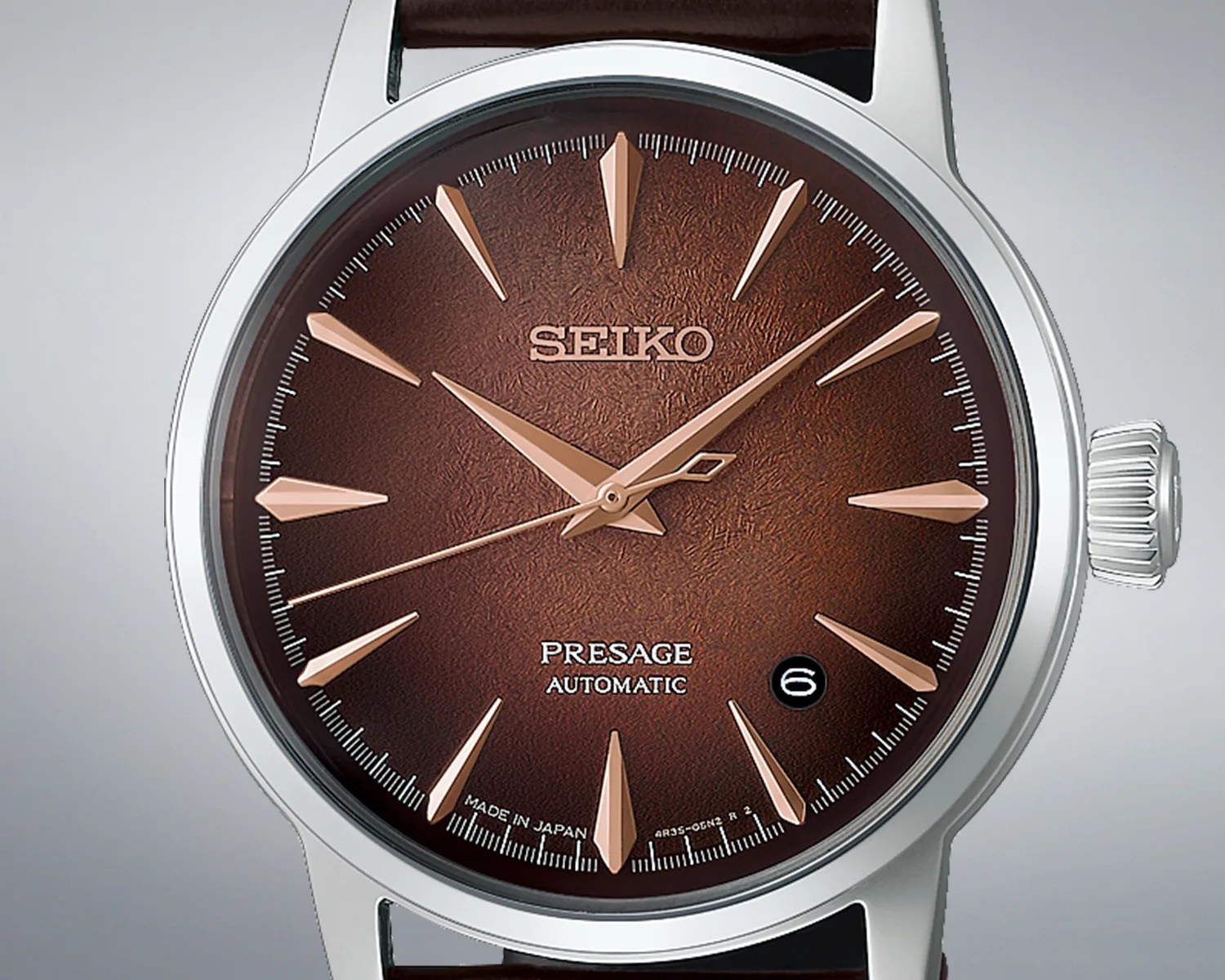 Close-up of a Seiko Presage automatic watch with a textured brown dial, rose gold markers and hands, and a date window at 4:30.
