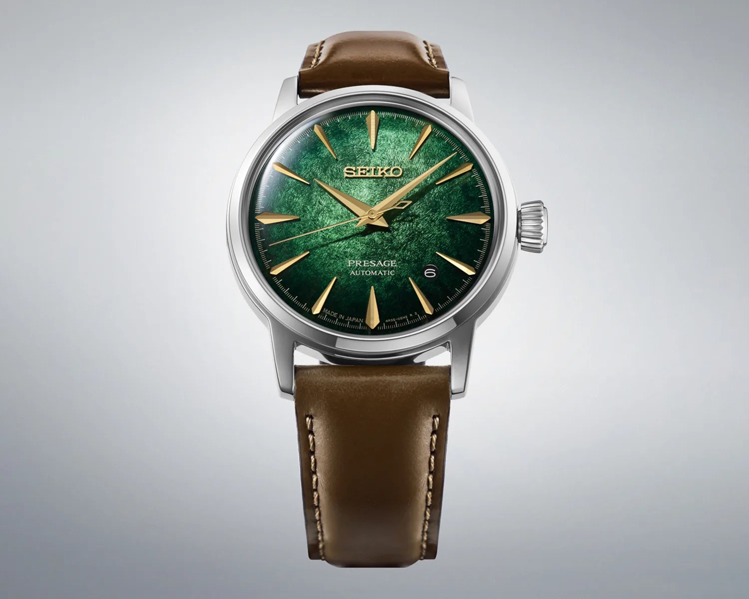 Silver Seiko Presage automatic watch with textured green dial, gold markers, and brown leather strap.