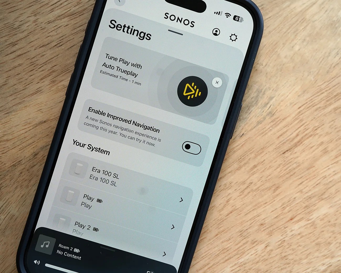 Smartphone screen showing Sonos app settings with options for Tune Play with Auto Trueplay and system devices listed.