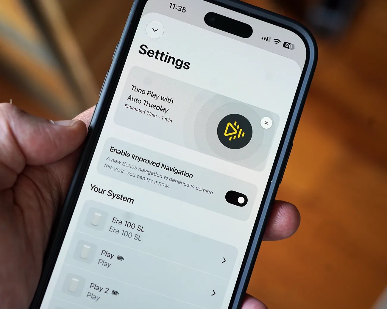 Smartphone screen showing Sonos app settings with options for Trueplay tuning and navigation toggle.