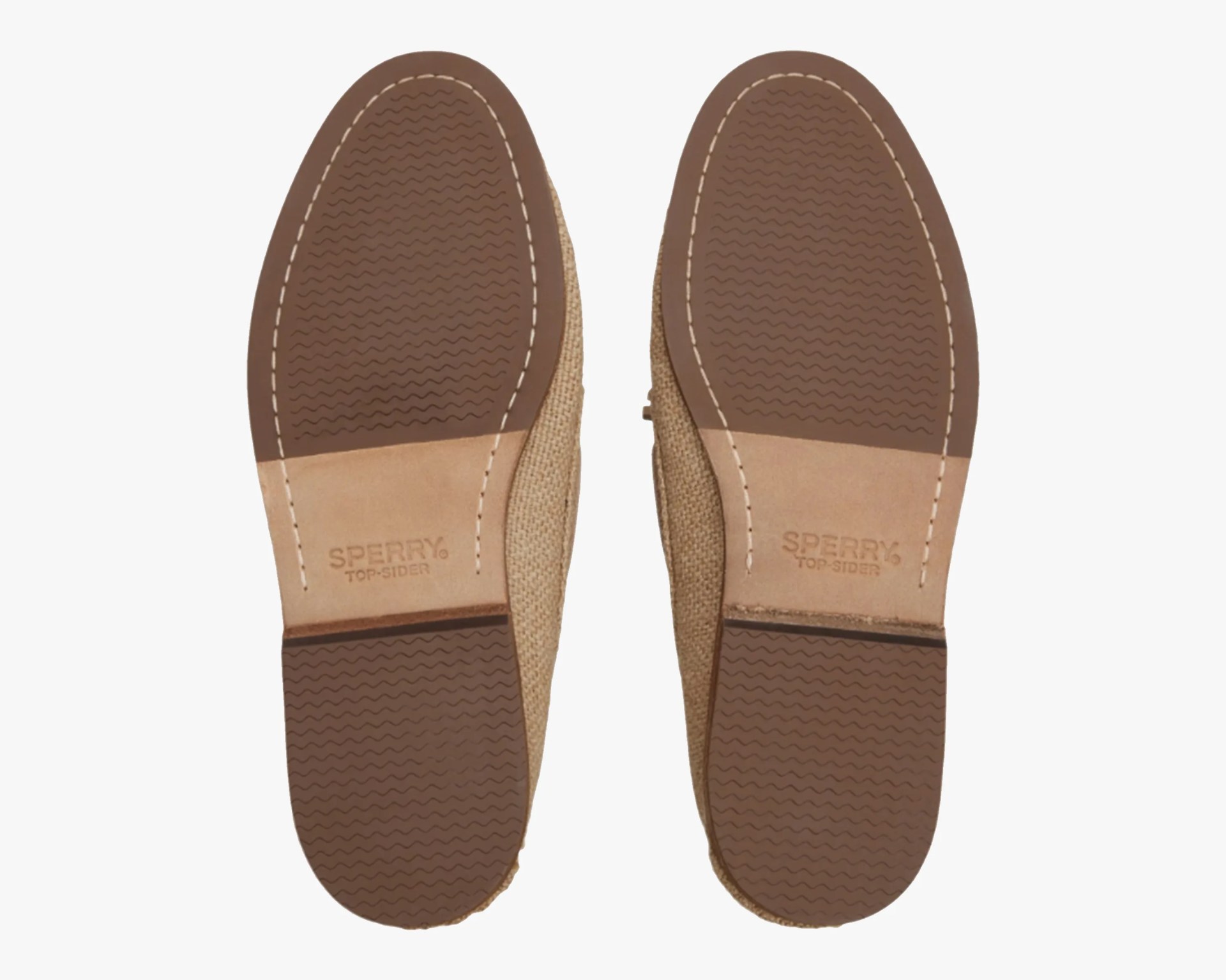 Pair of beige Sperry Top-Sider shoes showing brown rubber soles with wave tread pattern.