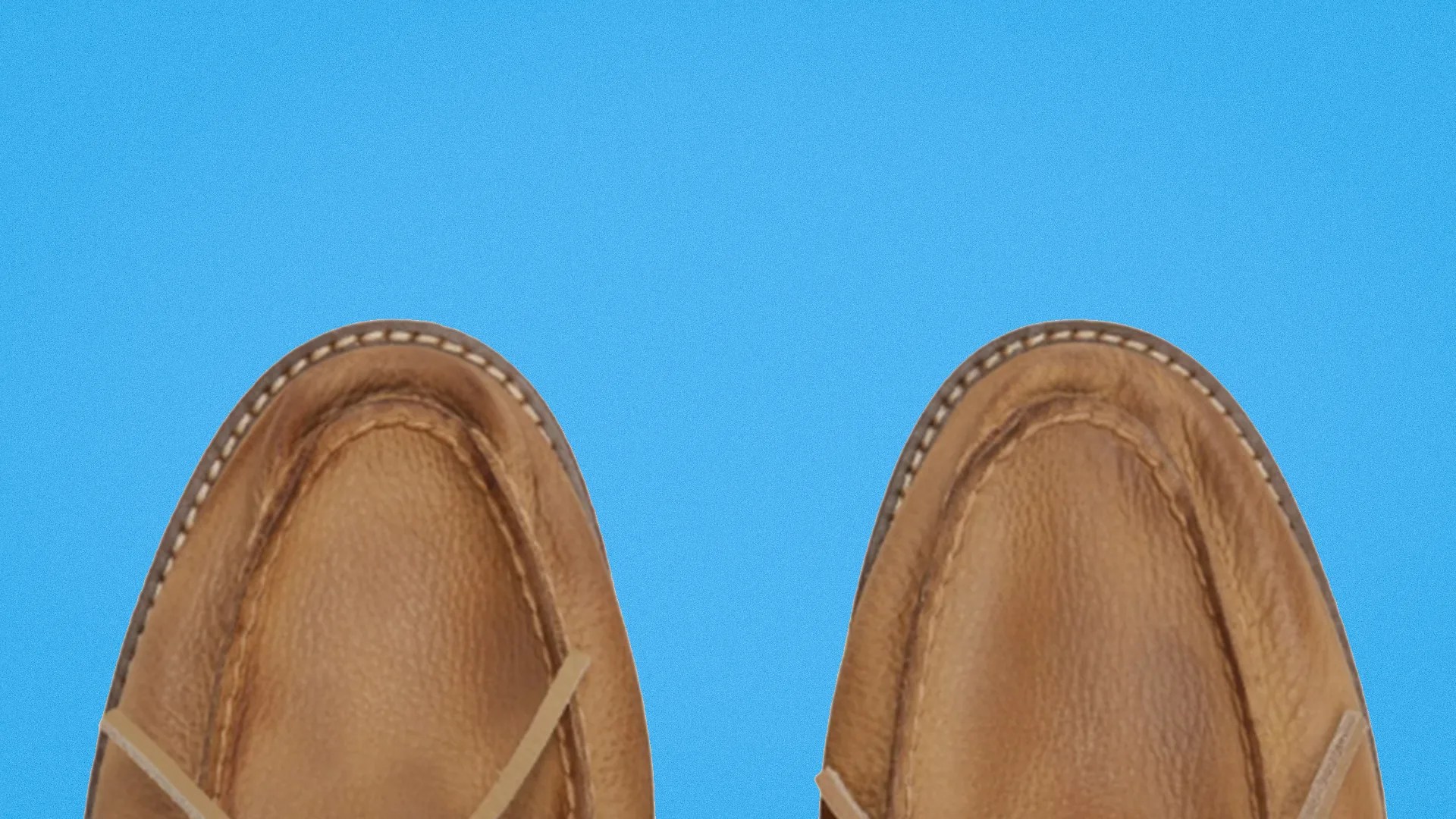 Pair of tan leather moccasin shoes with visible stitching on a blue background.