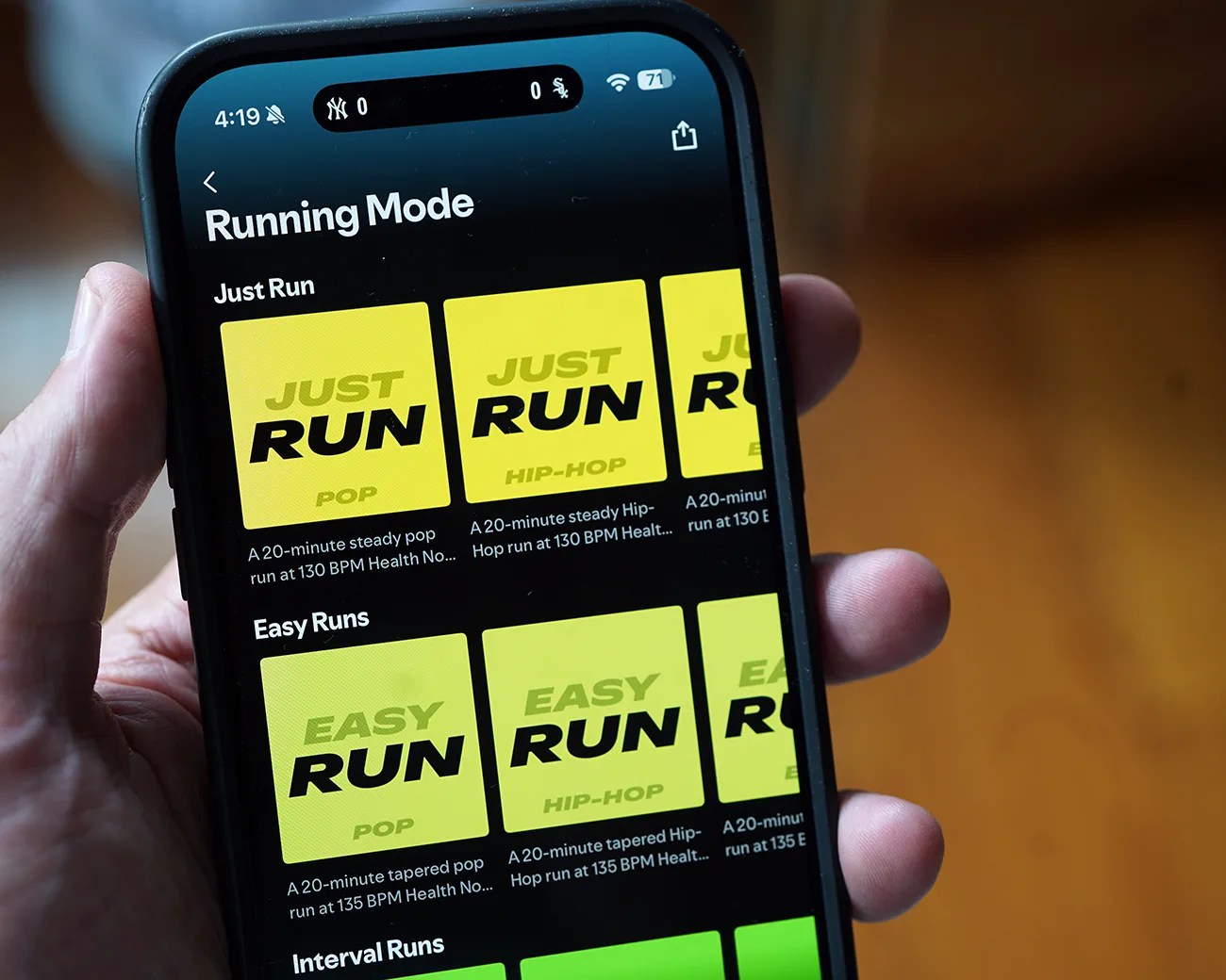 Smartphone screen showing a running app with "Running Mode" and music options for Just Run and Easy Runs in yellow tiles.