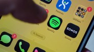 Close-up of a smartphone screen showing app icons including Spotify, Sonos, Messages with 7 notifications, and Utilities with 1 notification.