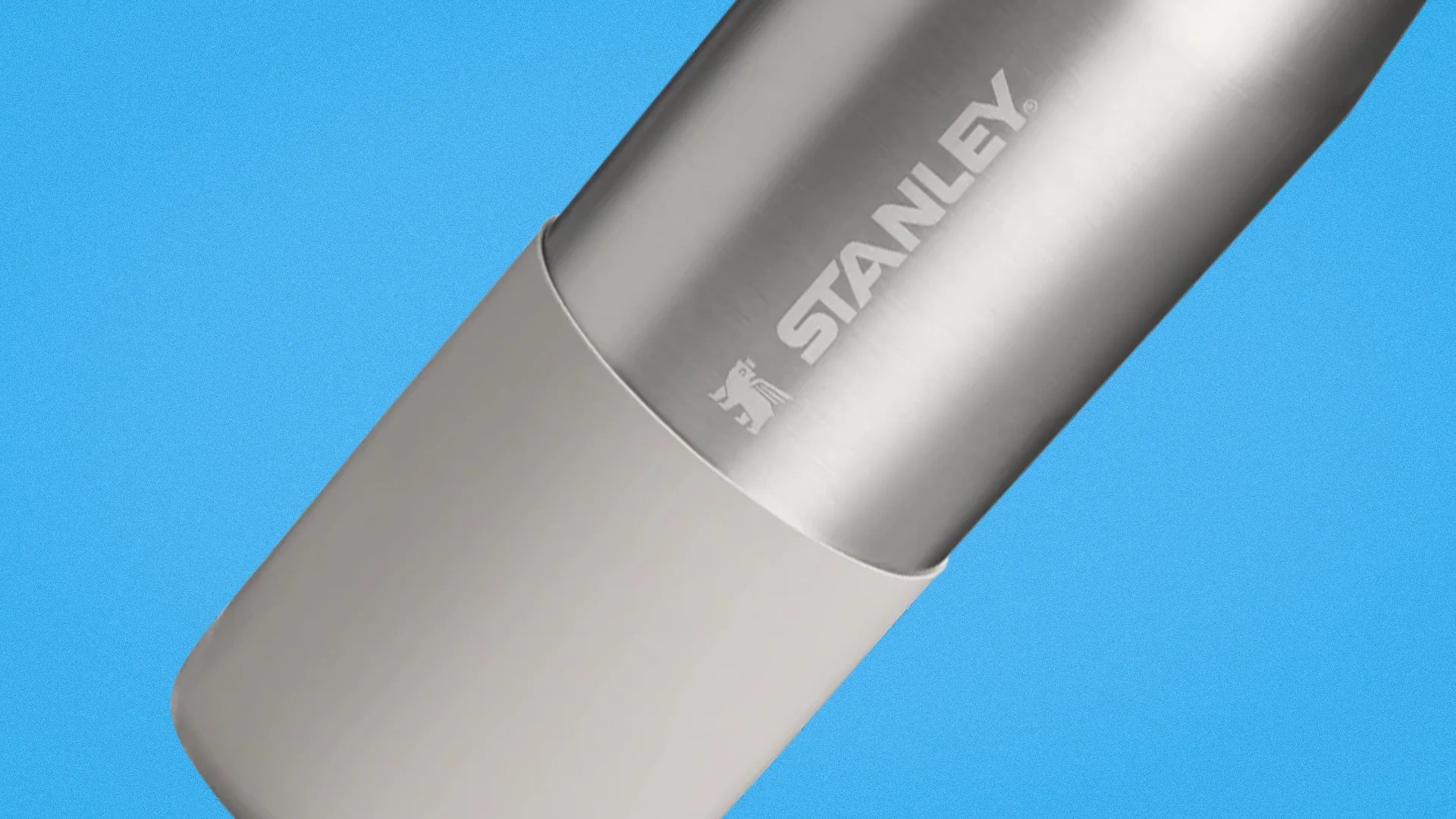 Silver Stanley stainless steel tumbler with a white base on a blue background.