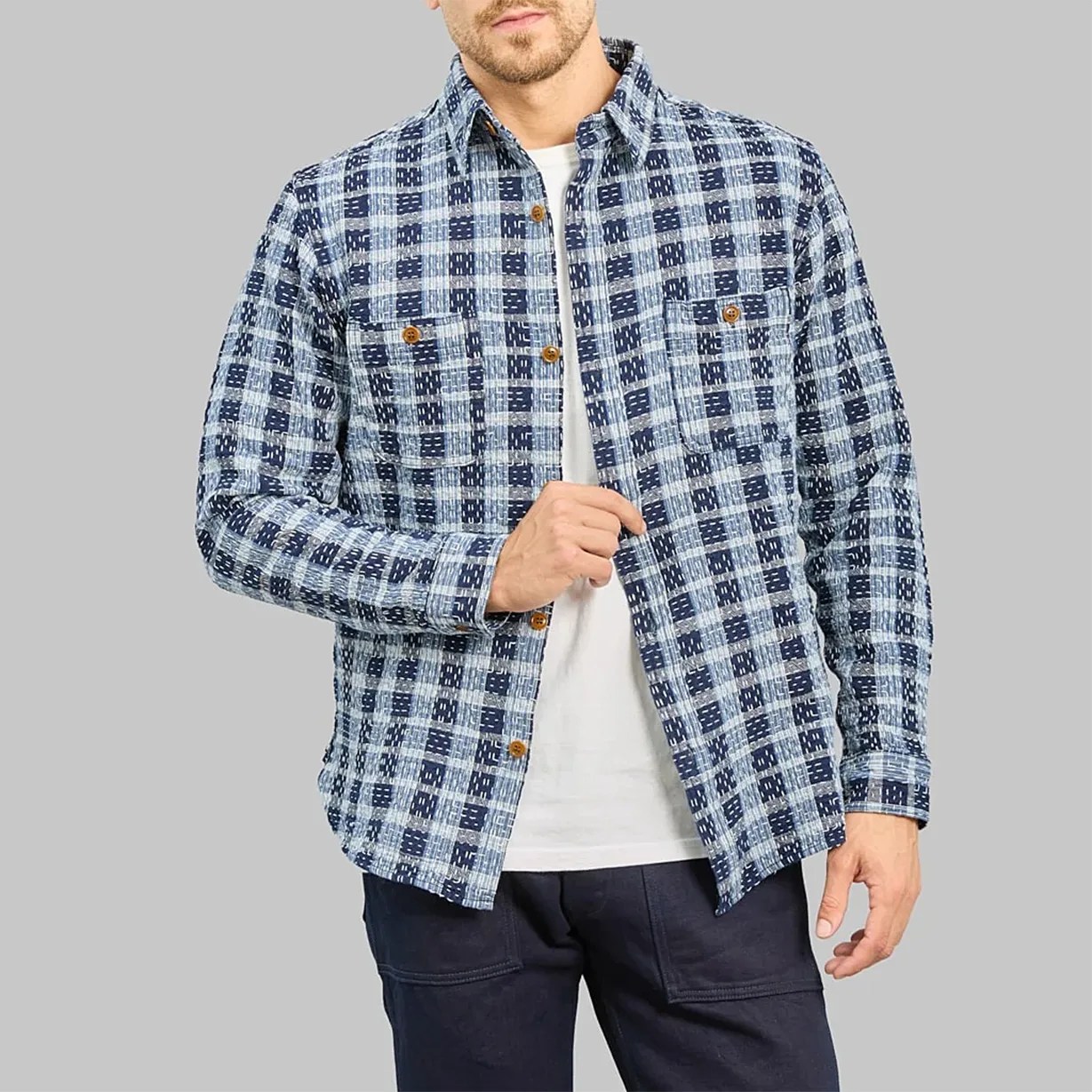 Blue and white checkered button-up shirt with chest pockets worn over a white t-shirt.