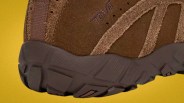 Close-up of the brown suede Teva shoe sole with textured rubber outsole on a yellow background.