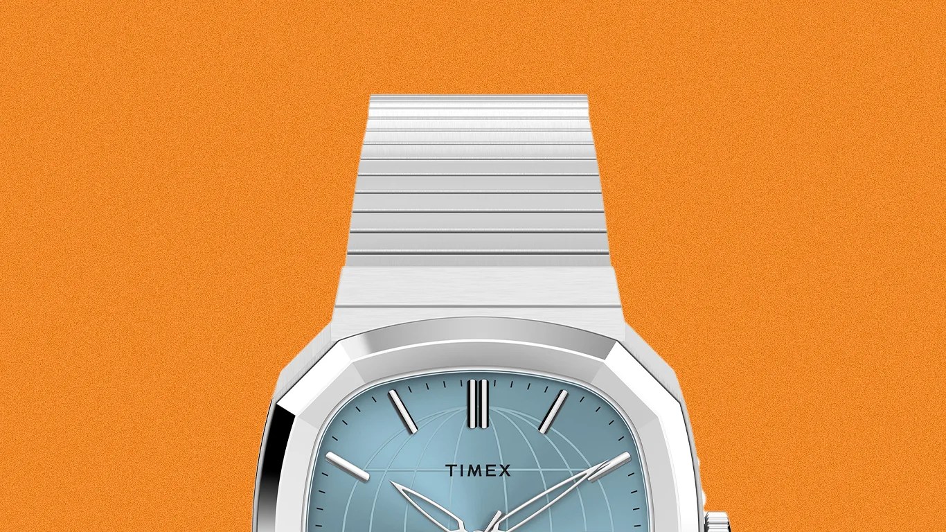 Silver metal Timex wristwatch with a light blue dial featuring a globe design and silver hour markers on an orange background.