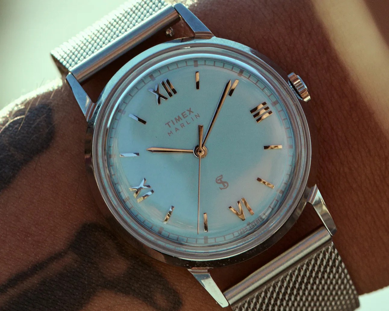 Silver Timex Marlin wristwatch with a light blue dial and Roman numeral hour markers on a mesh metal strap.