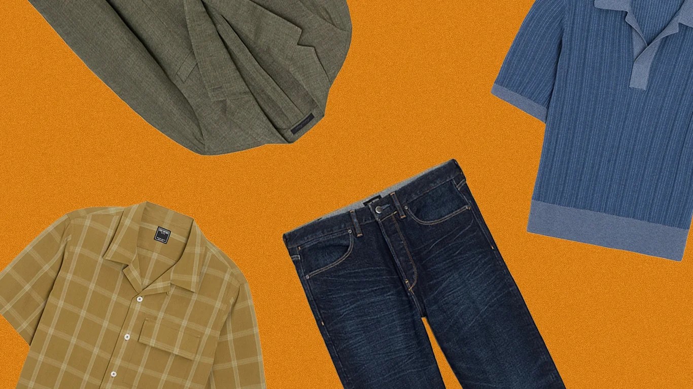Dark blue denim jeans with visible whiskering texture laid flat on an orange background.