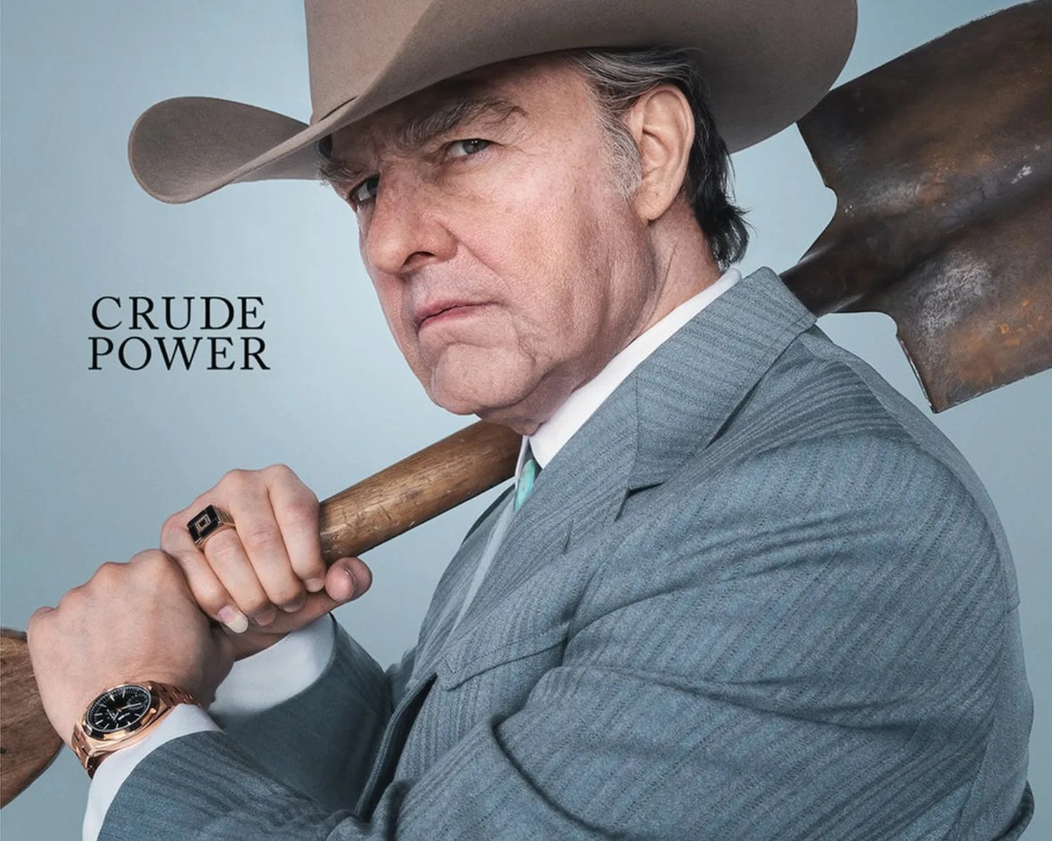 Man in a gray pinstripe suit and brown cowboy hat holding a shovel over his shoulder with "CRUDE POWER" text.