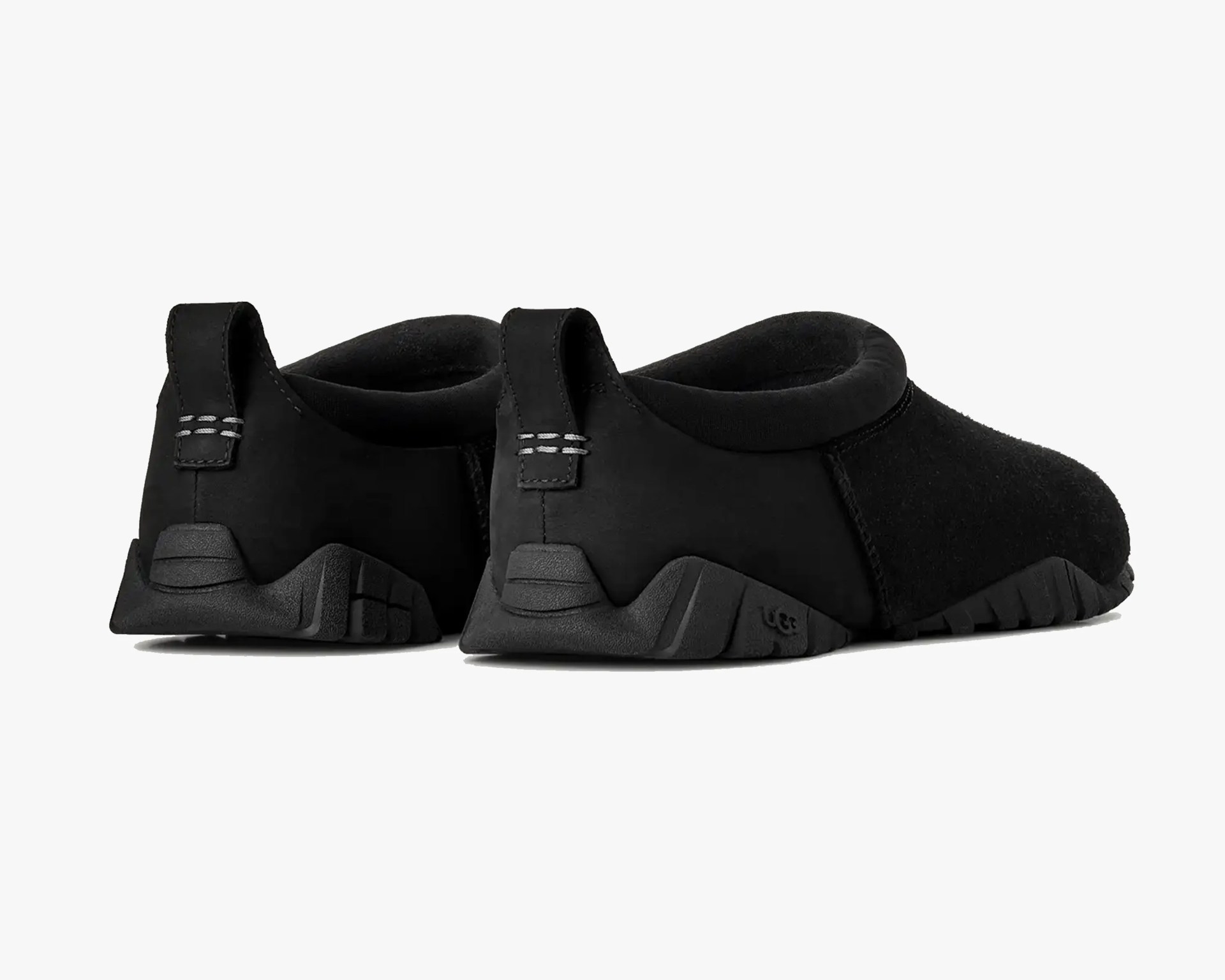 Pair of black slip-on shoes with thick textured soles and pull tabs at the heel.