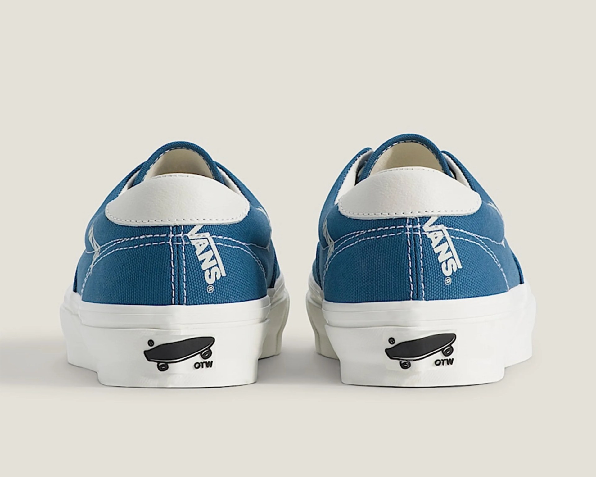 Pair of blue Vans sneakers with white heel tabs and white soles featuring a black skateboard graphic and "OTW" text.